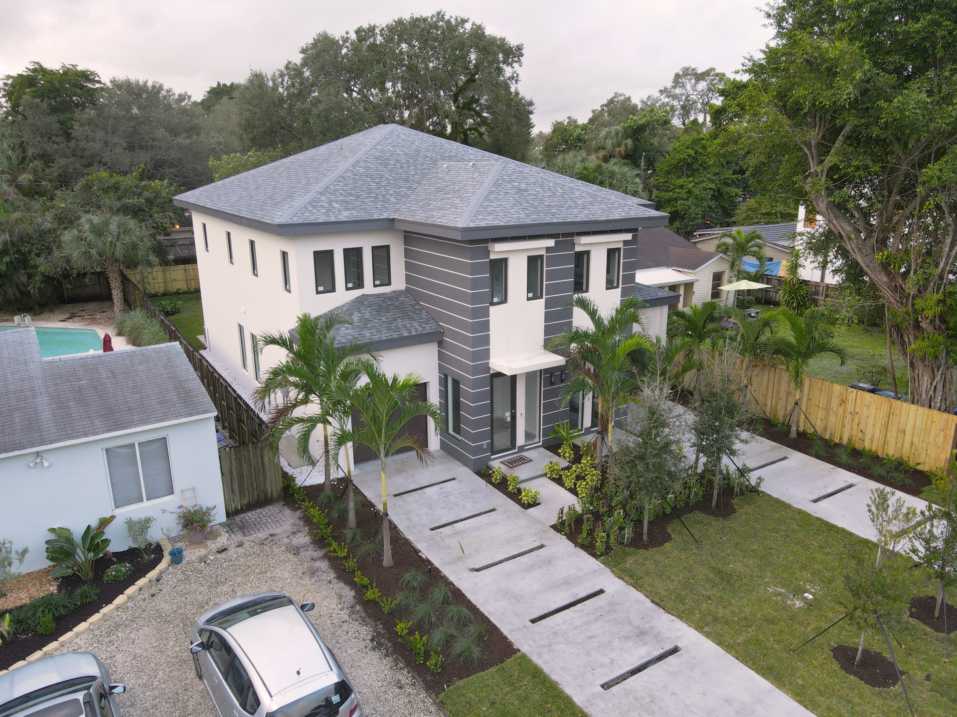 an aerial view of a house with cars parked in front of it