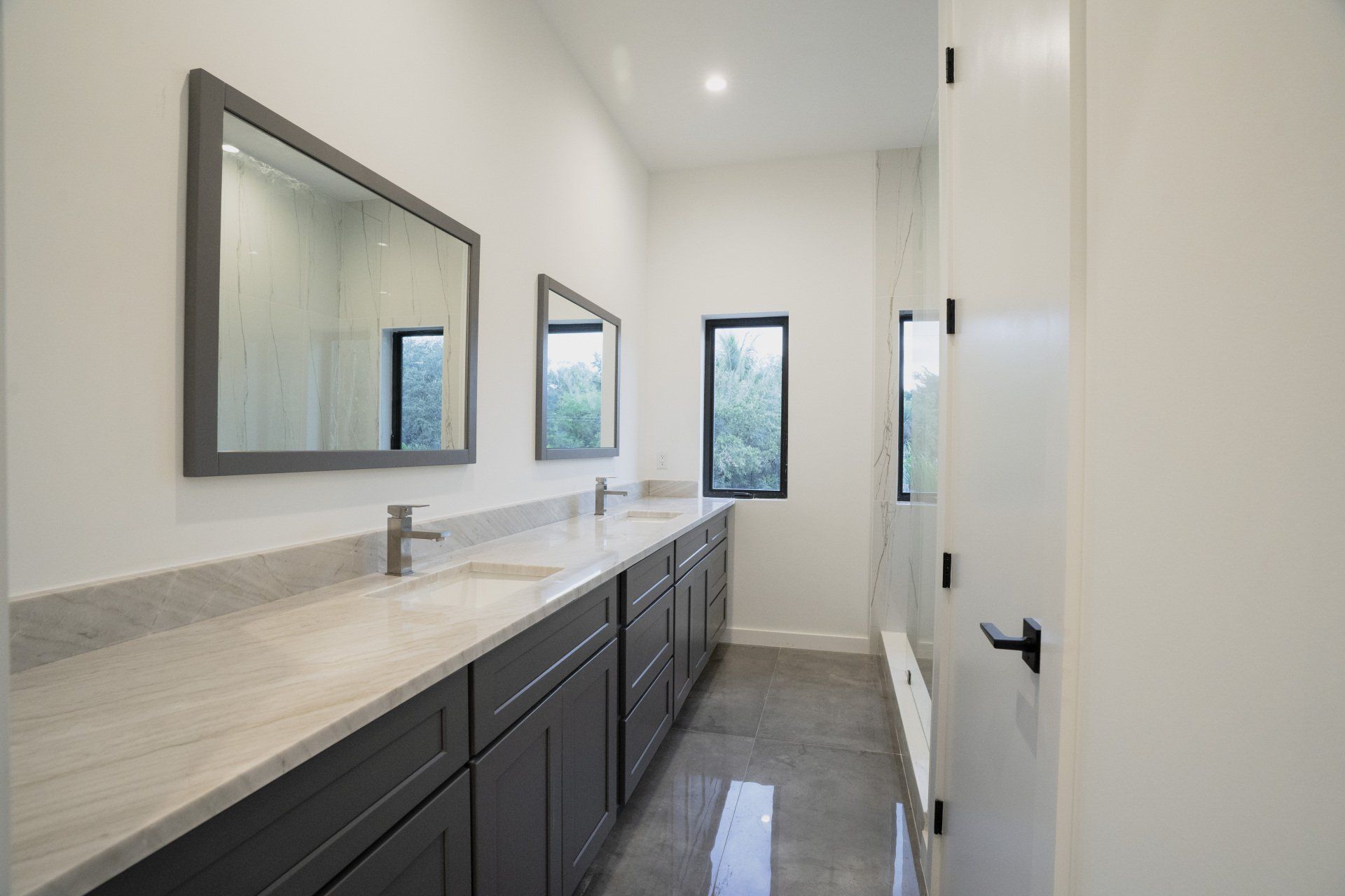 a bathroom with two sinks and two mirrors .
