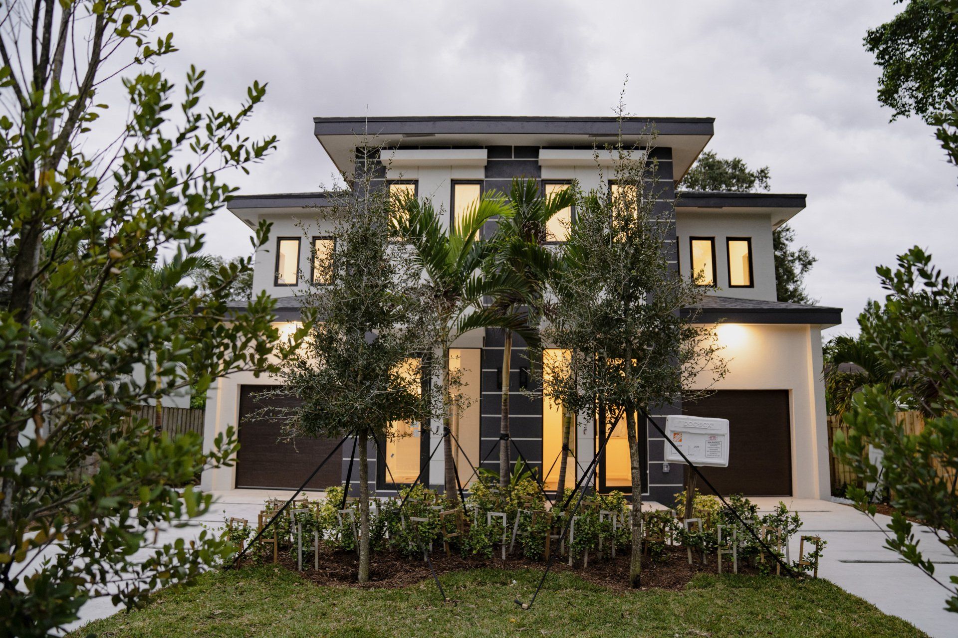 a house with a lot of windows and trees in front of it