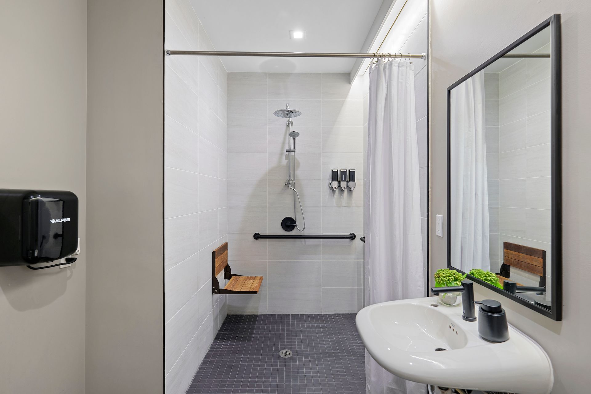 A bathroom with a sink and a walk in shower.