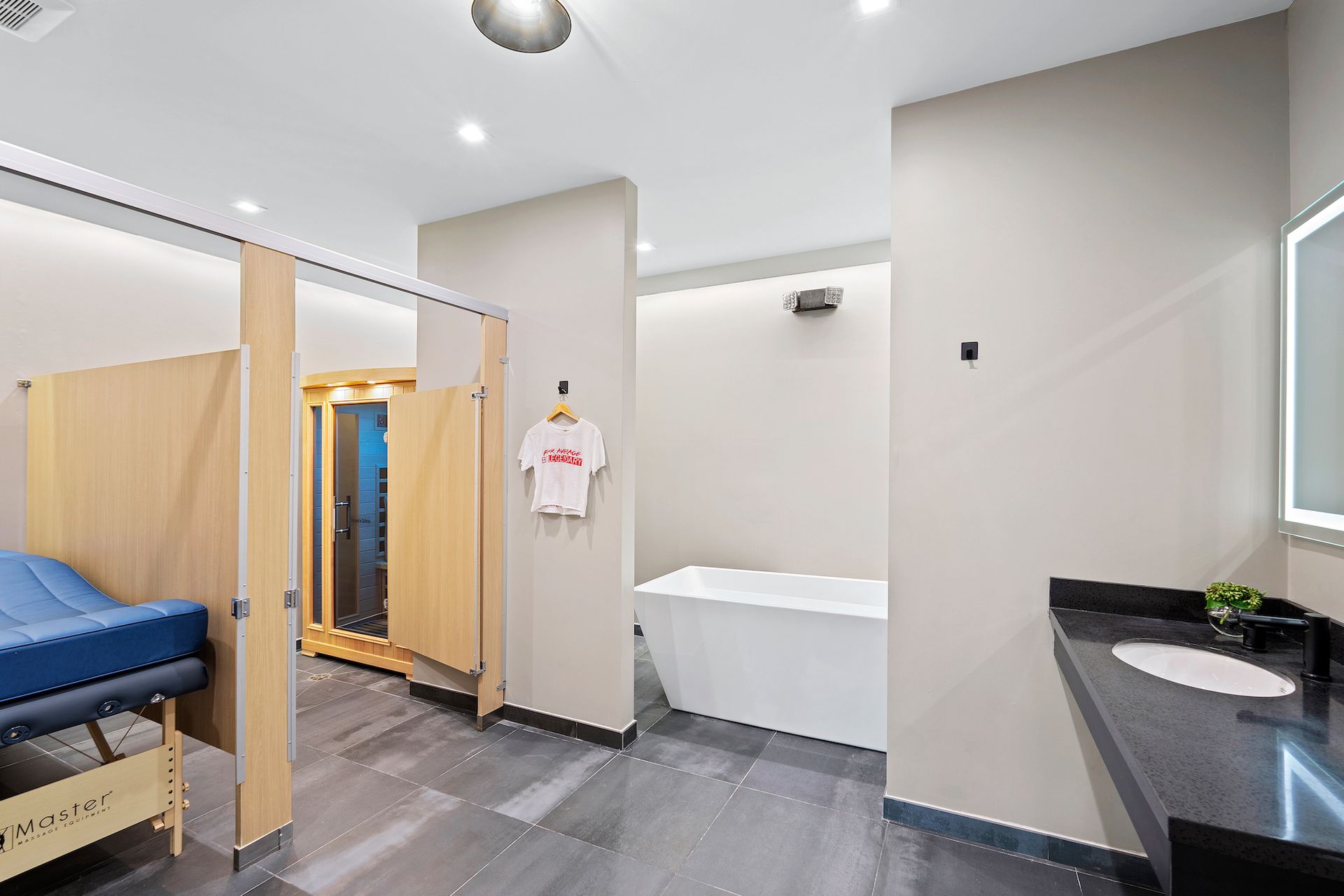 A bathroom with a bathtub , sink , and sauna.