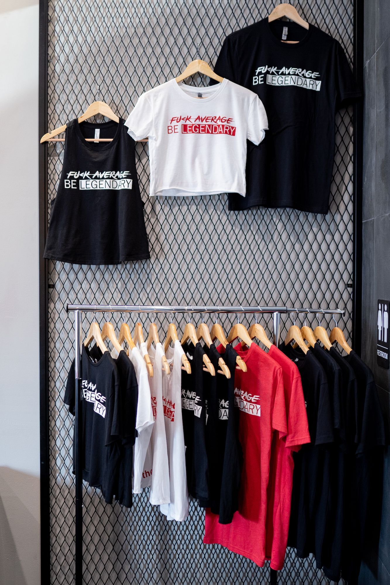 A bunch of t-shirts are hanging on a rack in a store.