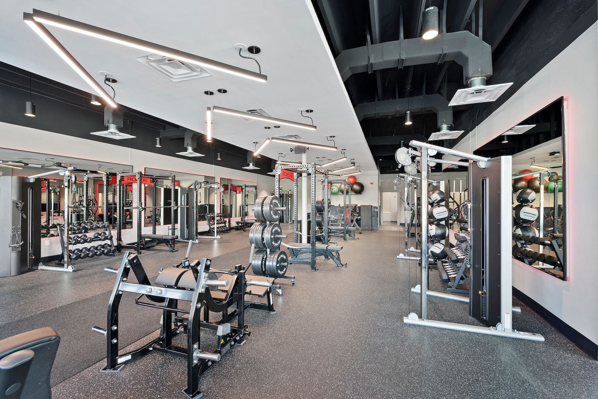 A large gym filled with lots of exercise equipment.
