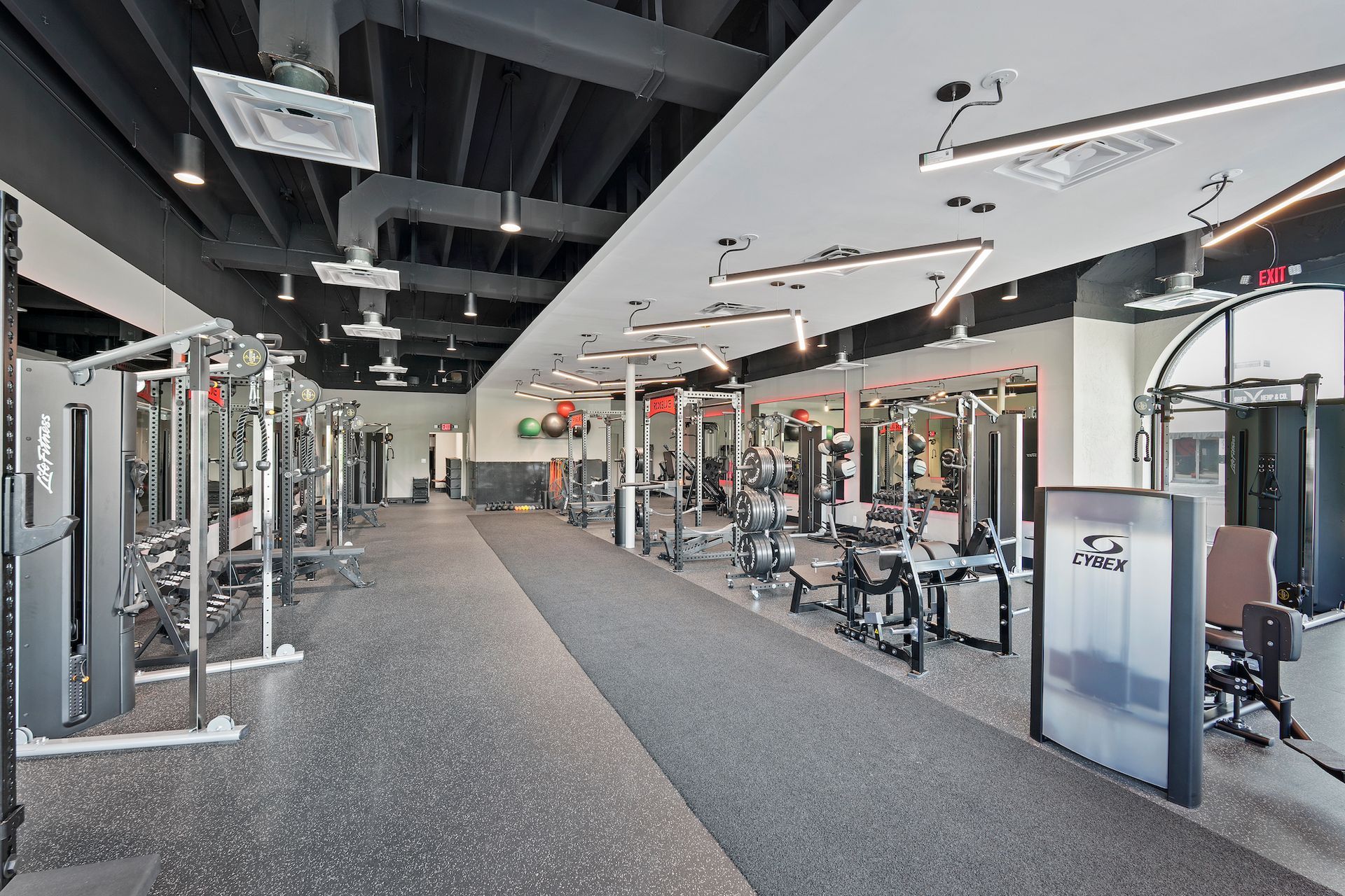 A large gym filled with lots of exercise equipment.
