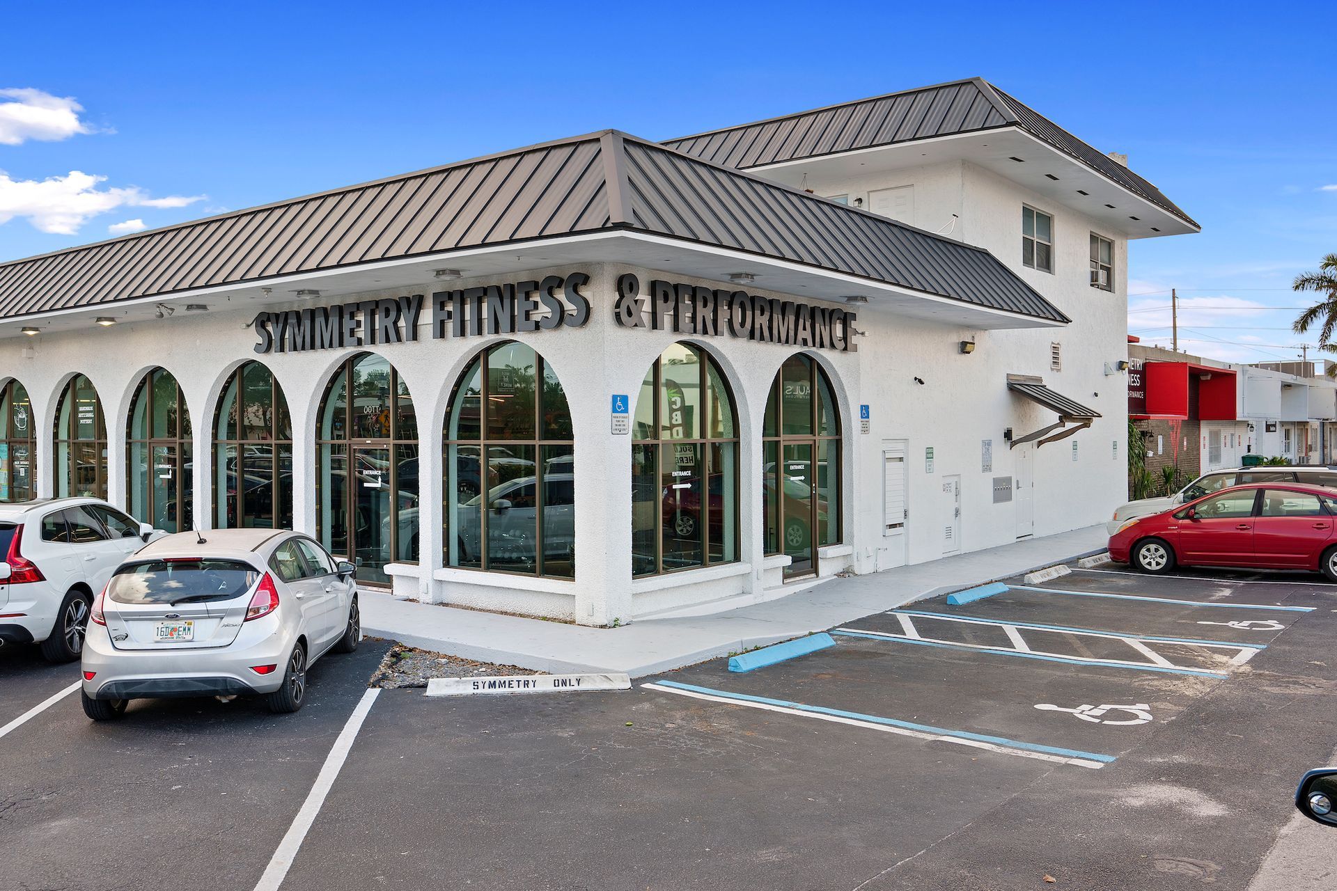 A white building with a sign that says symmetry fitness & performance