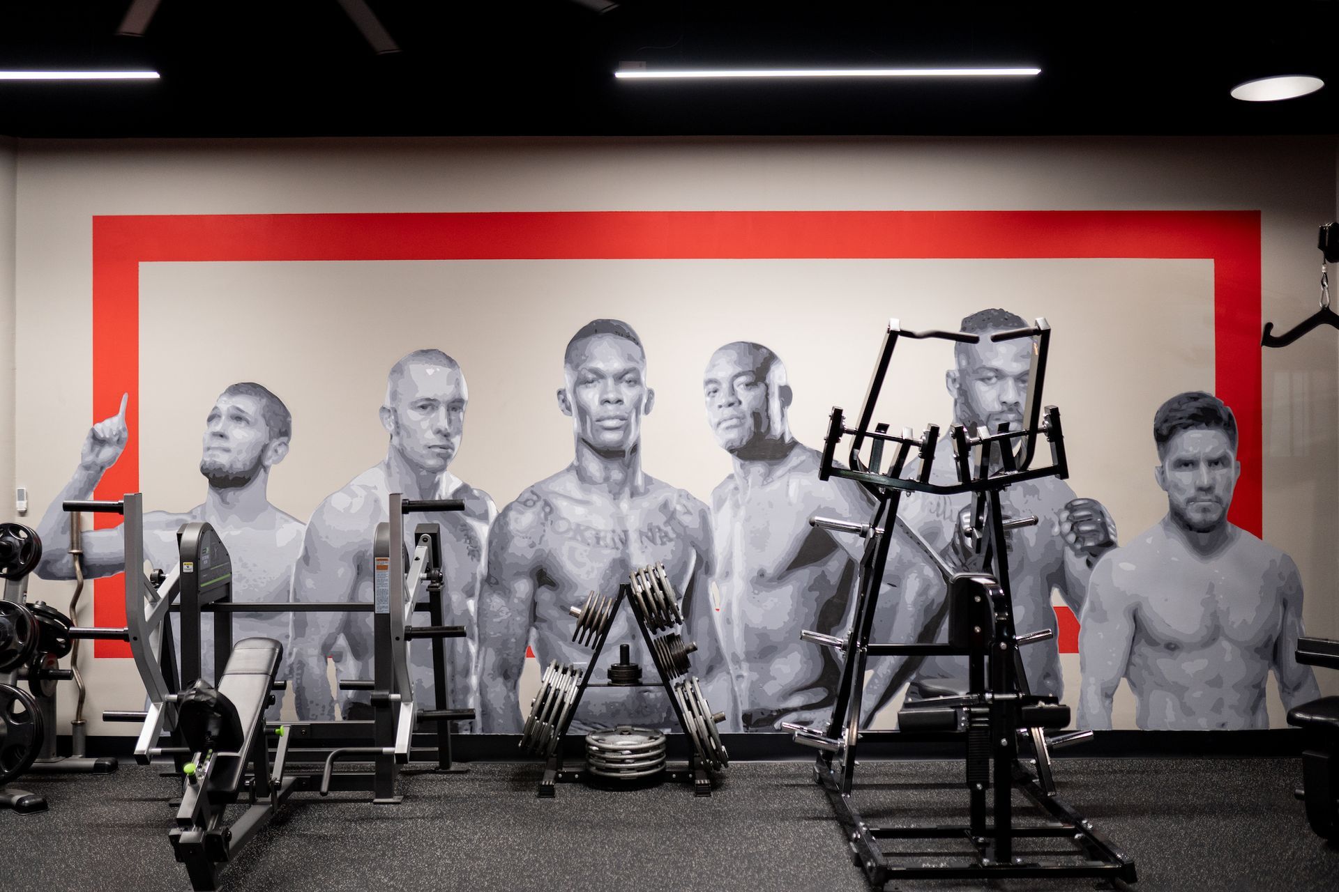 A group of men are standing next to each other in a gym.