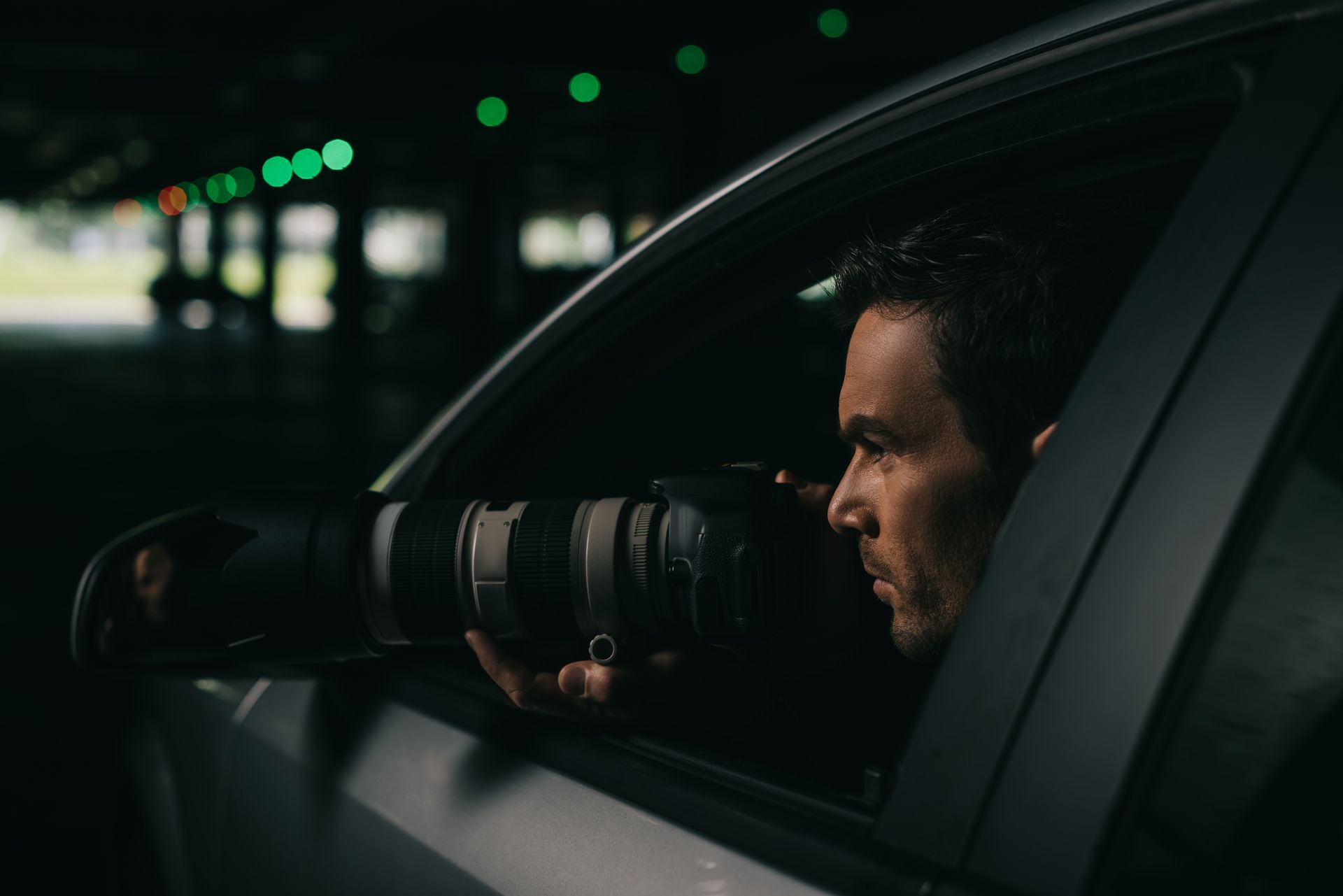 A man is taking a picture with a camera from the window of a car.