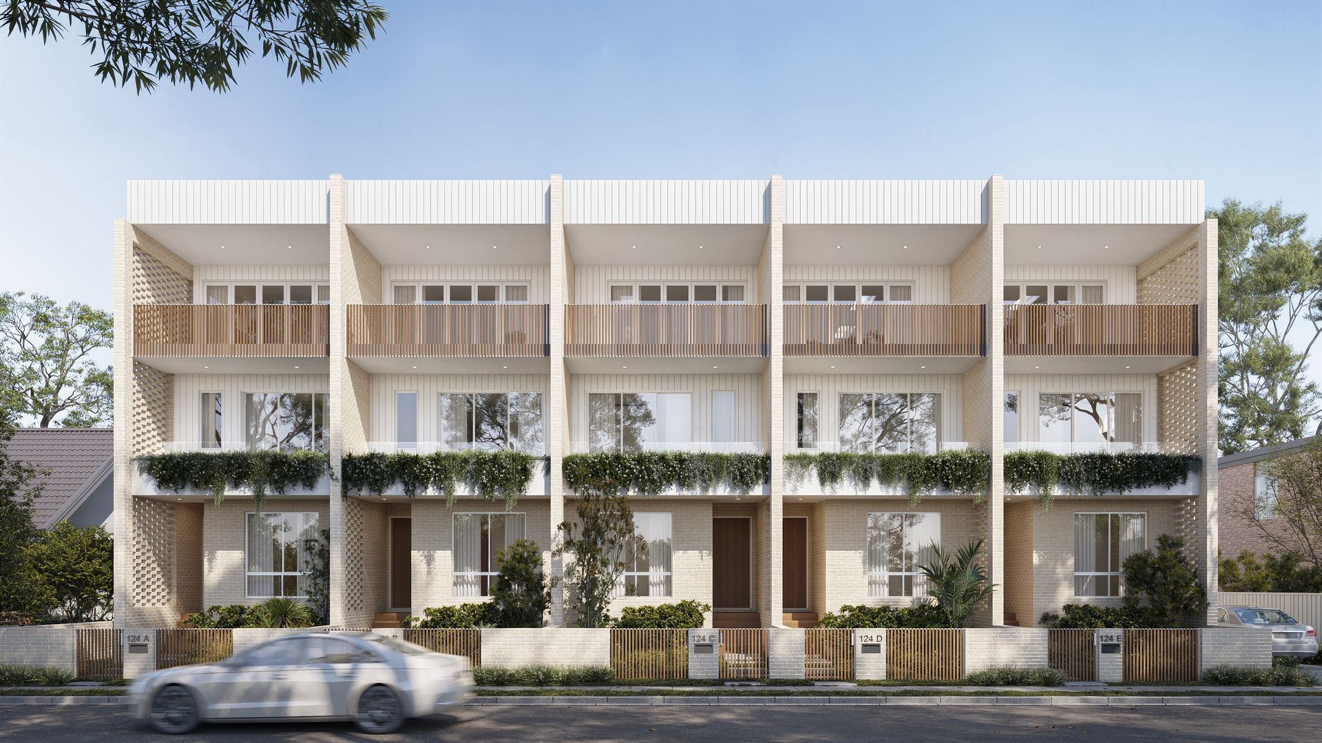 Row of modern terraces with balconies, cream facade, street view, car in foreground — Gracia Building Design In Kiama, NSW