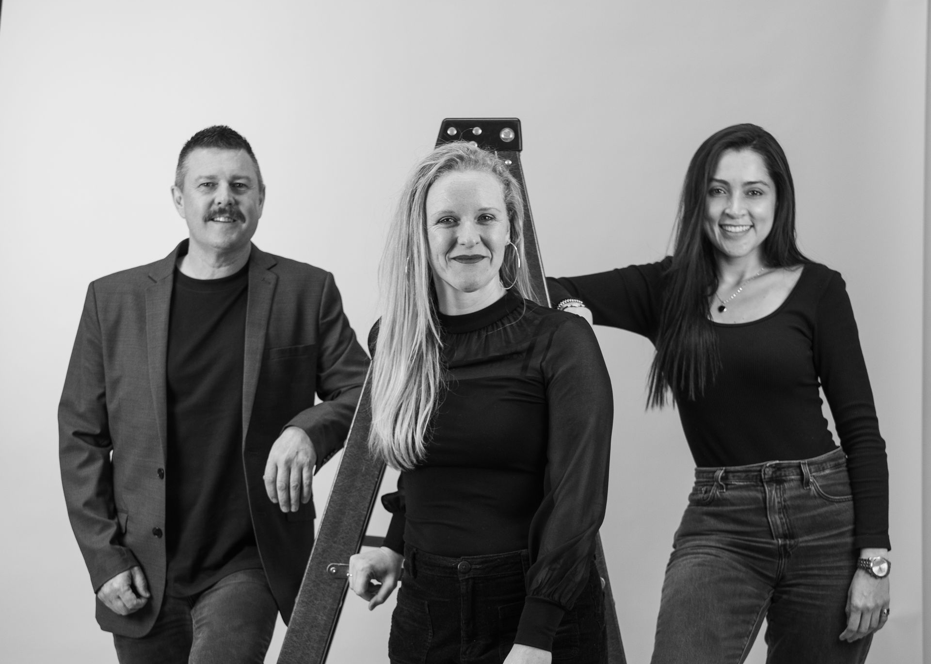 Three People Pose Near a Ladder. Woman in Middle Stands — Gracia Building Design In Kiama, NSW