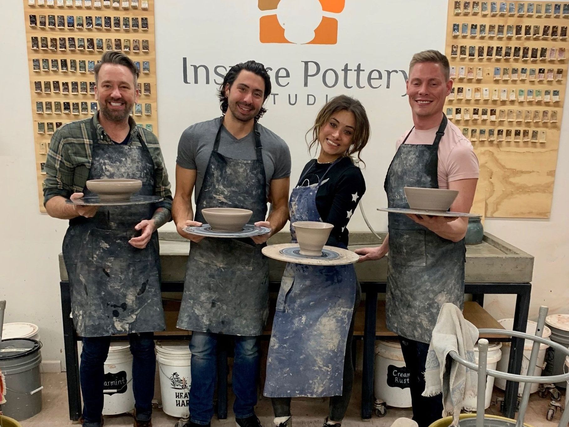 a group of people standing in front of a sign that says Inspire pottery