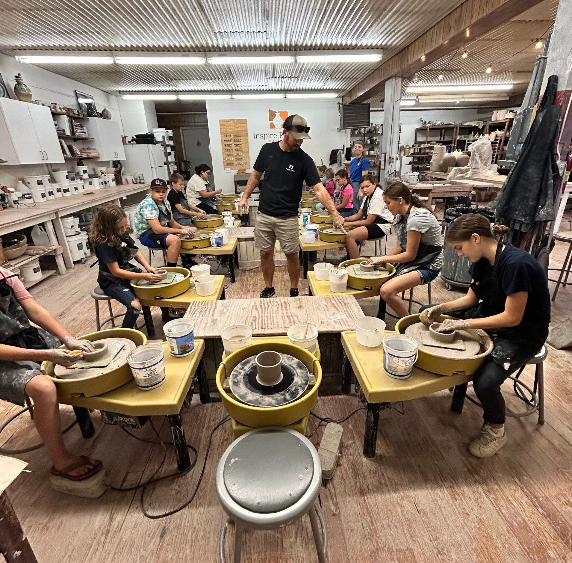 Joel Hildebrand teaching youth how to throw bowls at Inspire Pottery Studio Learning and having fun