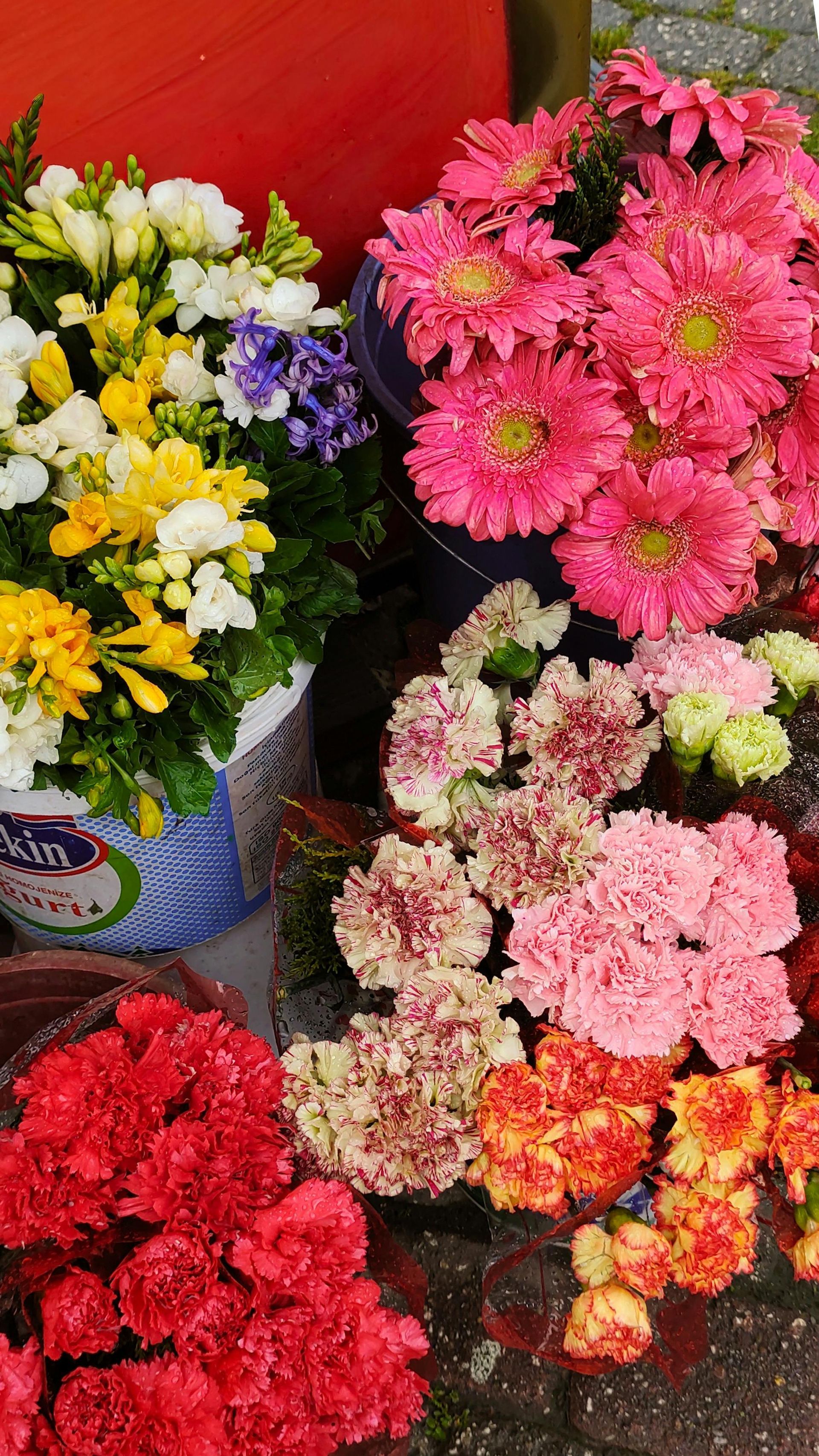 Assorted colorful bouquets of flowers in buckets at a market stall