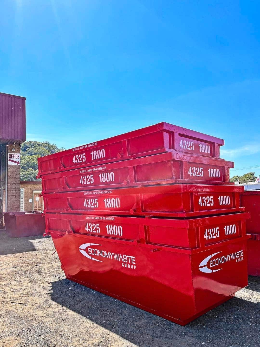 A Red Waste Bins Stacked Outdoors — Economy Waste Group | Skip Bins Central Coast In Umina, NSW