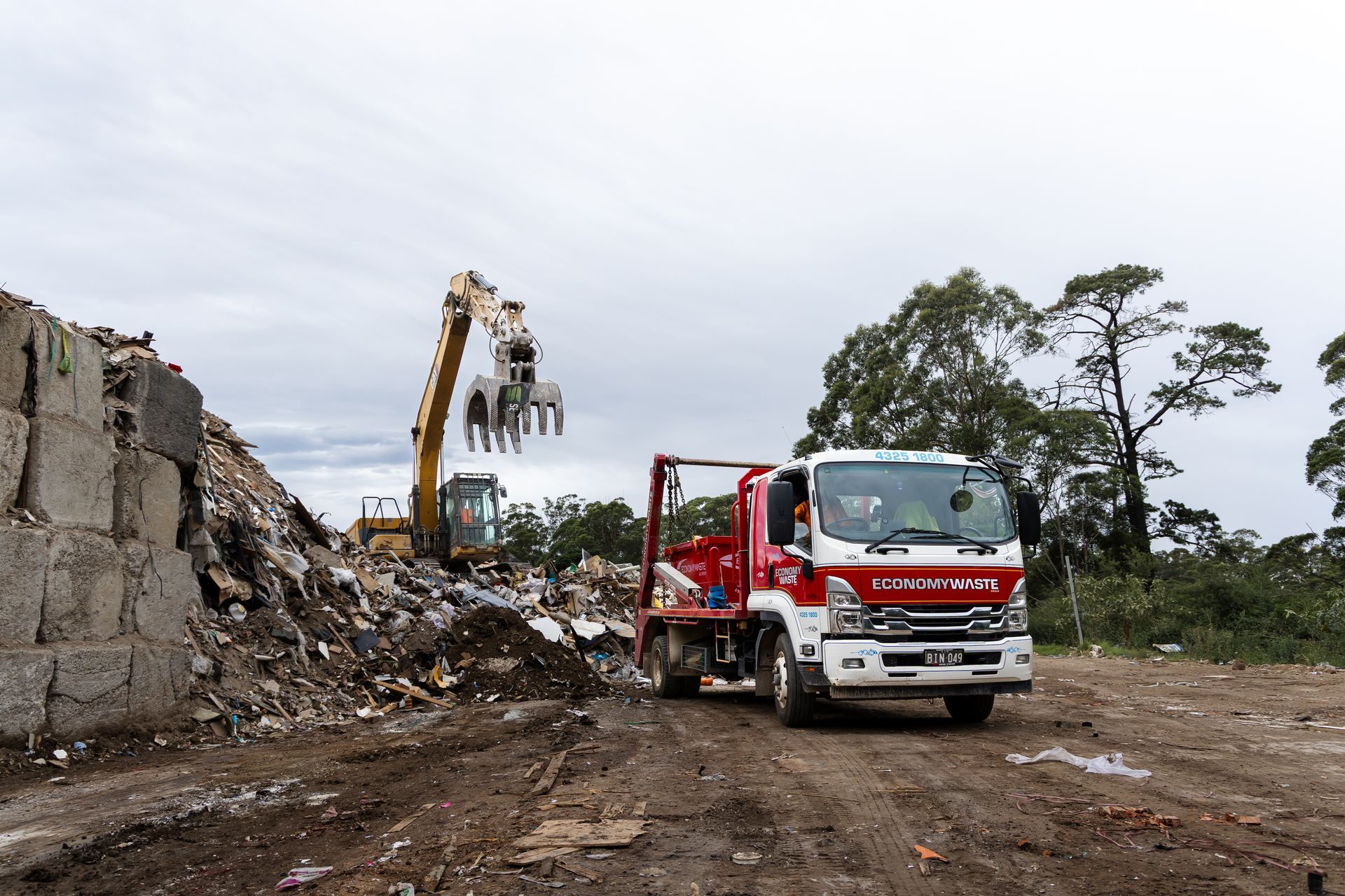 Demolition Site: Excavator Loading Debris — Economy Waste Group | Skip Bins Central Coast In Mannering Park, NSW