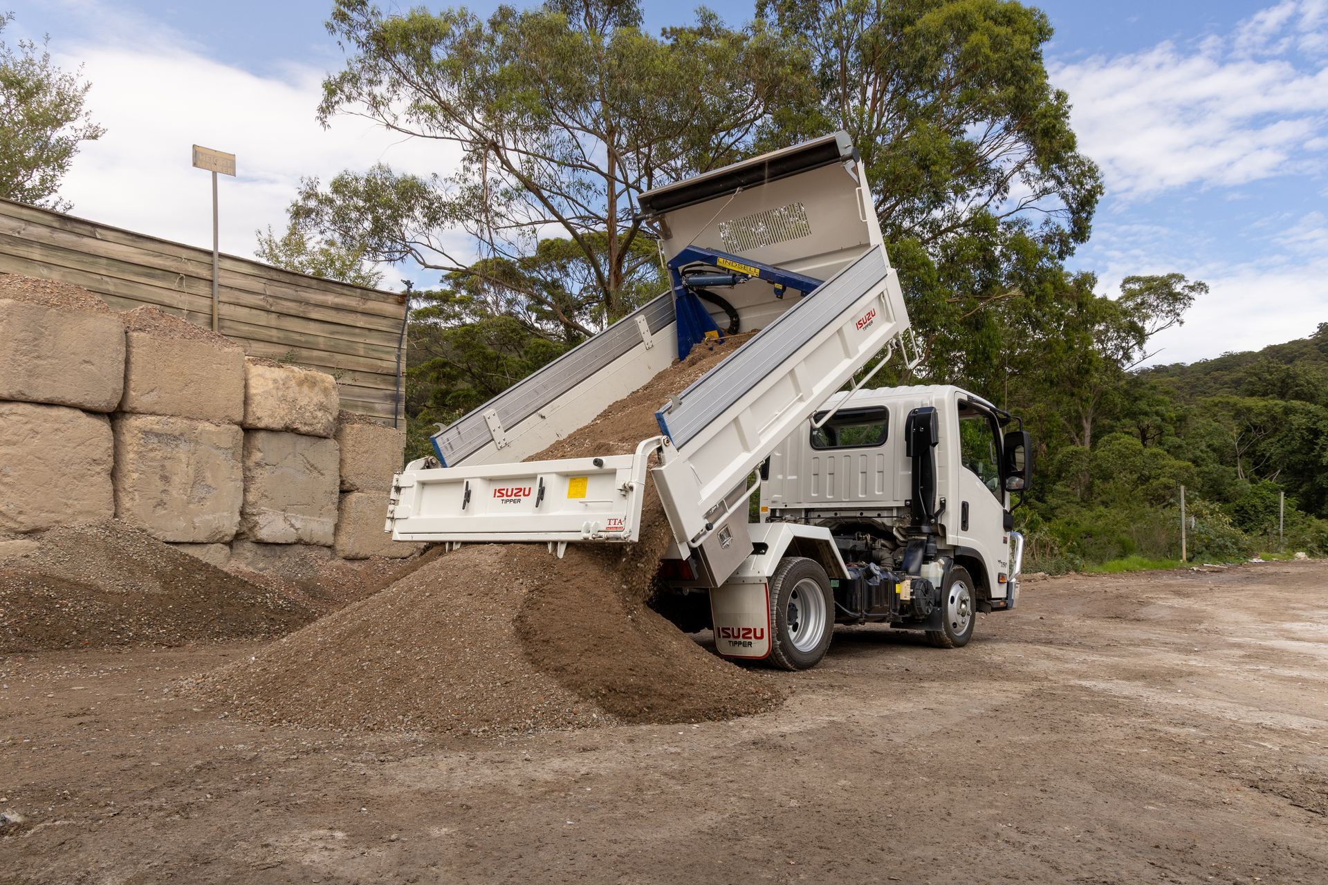 White Dump Truck Unloading Gravel — Economy Waste Group | Skip Bins Central Coast In Umina, NSW