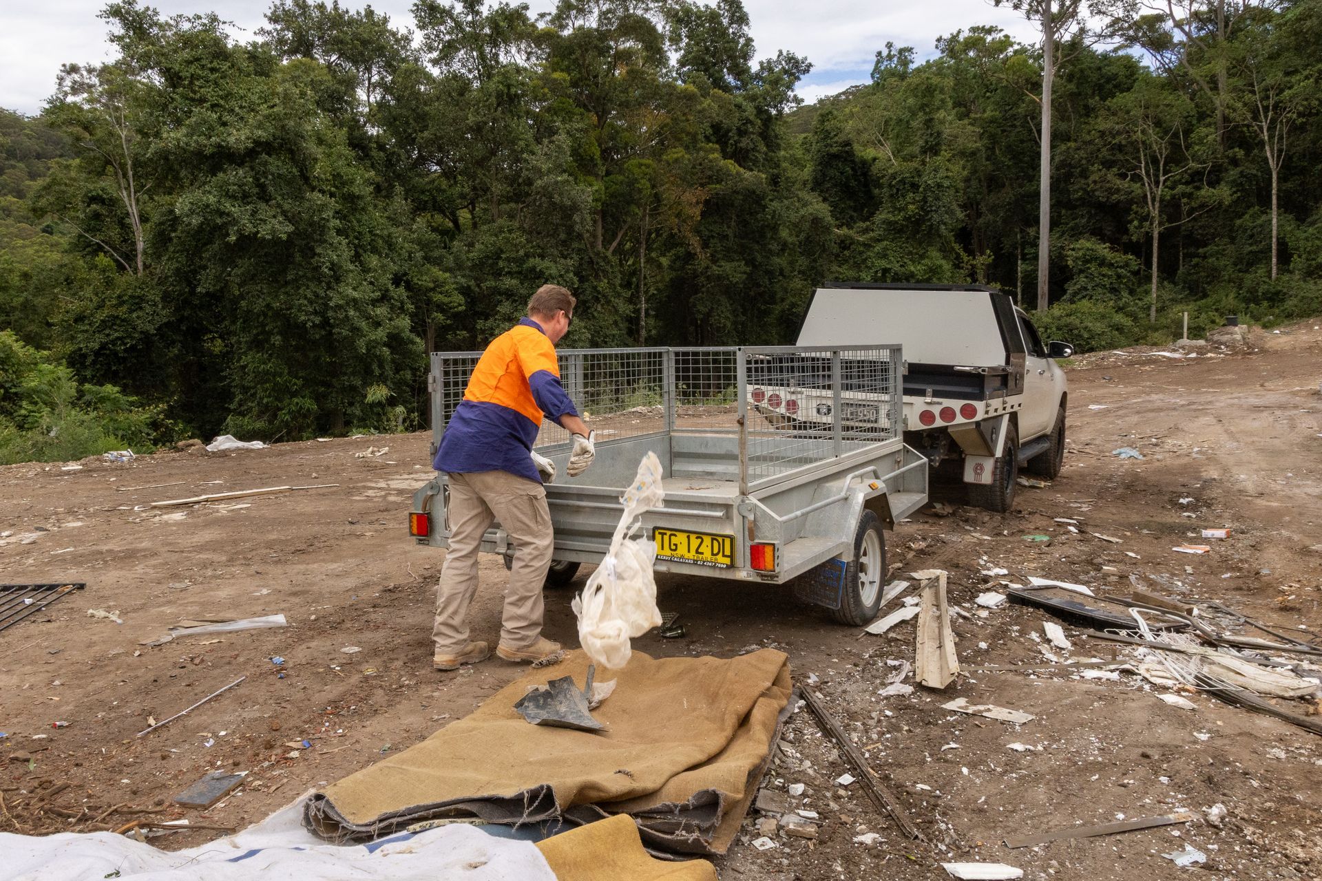 Person Loading a Trailer With Debris — Economy Waste Group | Skip Bins Central Coast In Wamberal, NSW