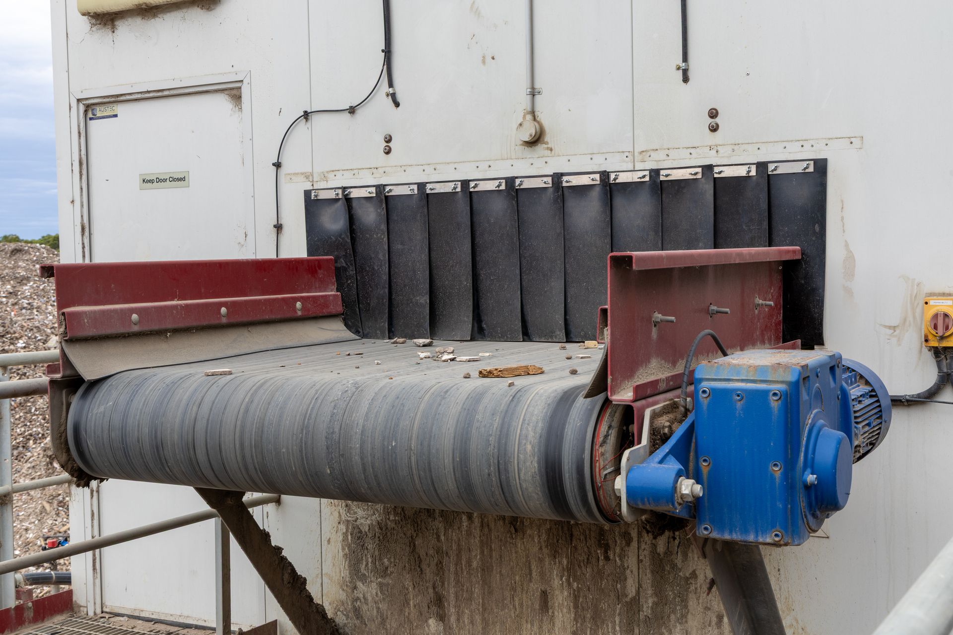 A Conveyor Belt, Dirty, Transports Material — Economy Waste Group | Skip Bins Central Coast In Avoca, NSW