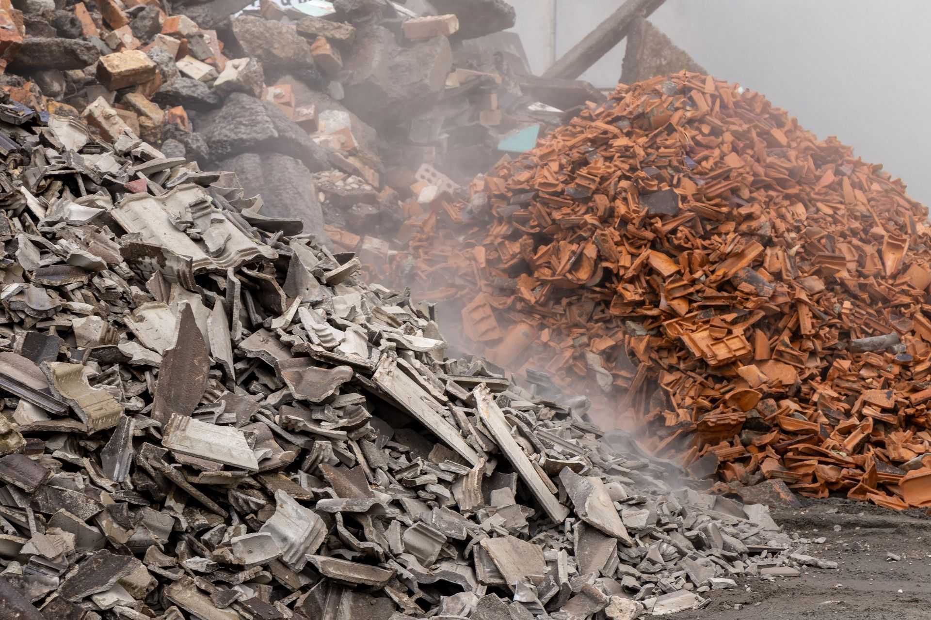 Piles of Grey and Red Construction Debris — Economy Waste Group | Skip Bins Central Coast In Killcare, NSW