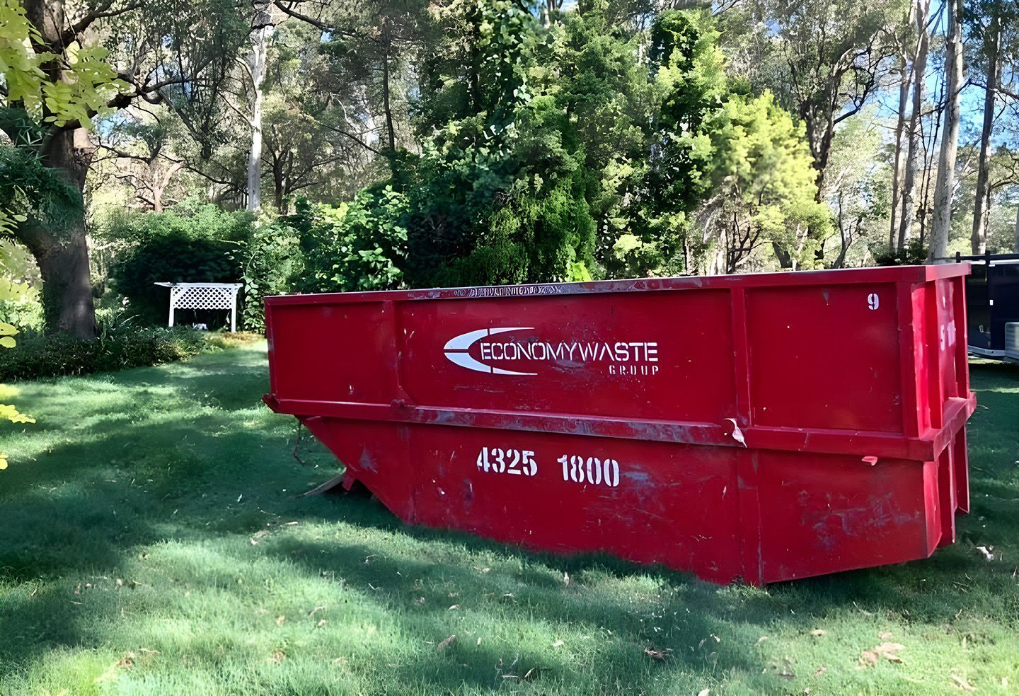 Red Skip Bin Hire Placed On Grassy Yard