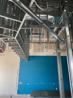 Interior construction showing metal framing and blue painted wall.