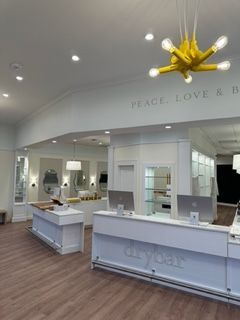 Interior of a Drybar salon, with white counters, lighting, and a yellow fixture; the words 