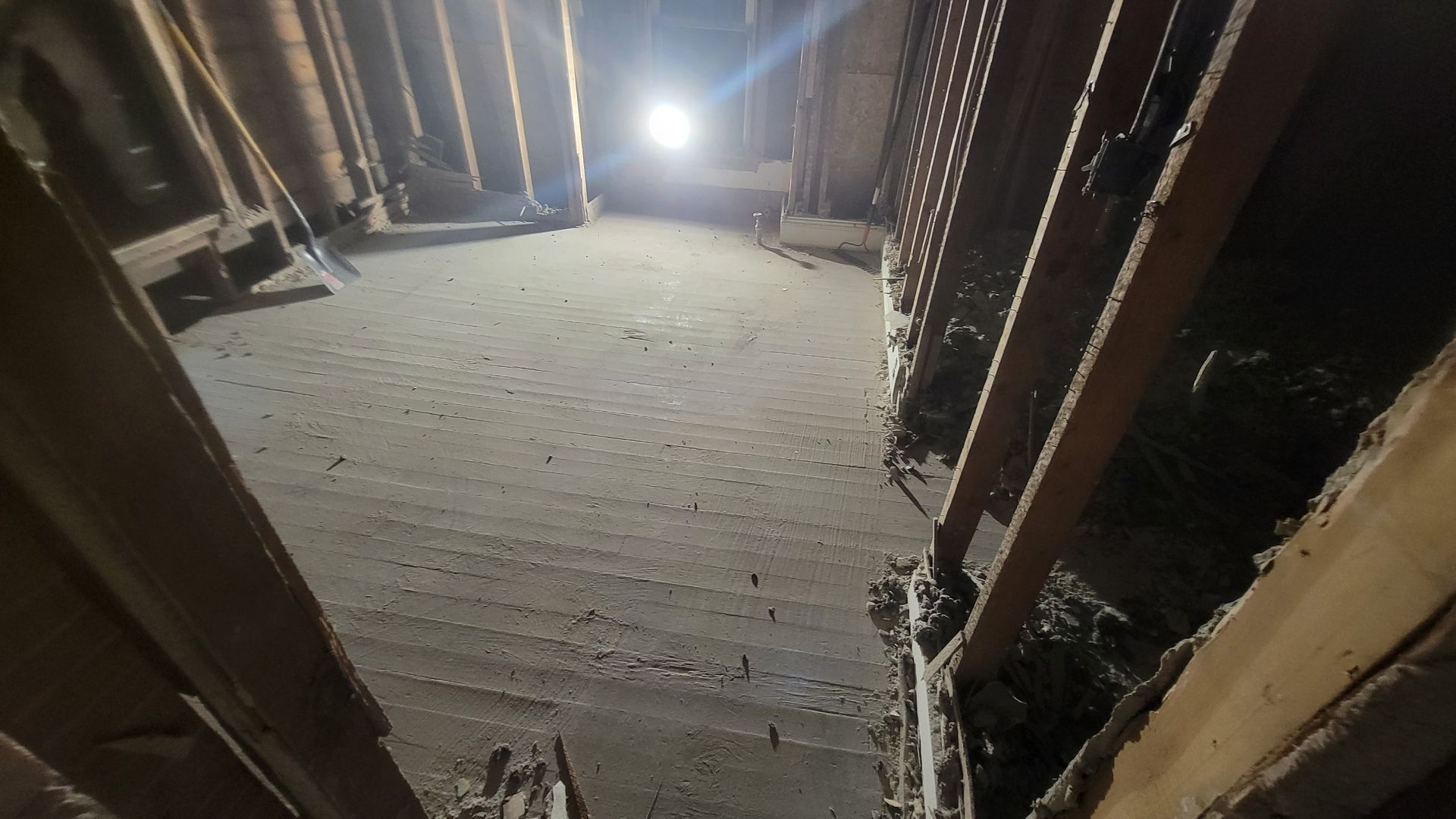 A dark attic with a light on the ceiling.
