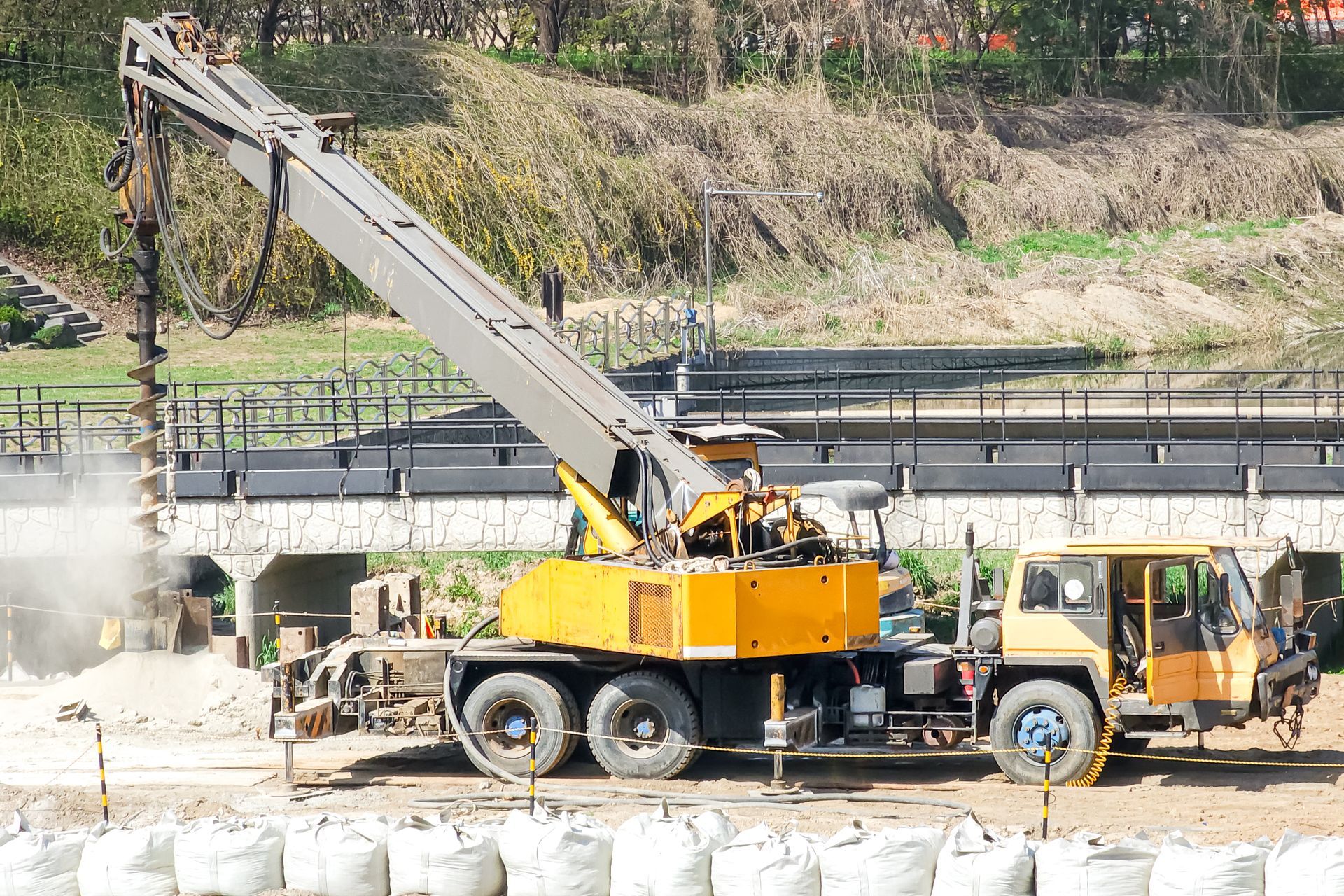 Truck mounted auger drilling hole in soil for fence post foundation construction equipment close up. Truck mounted auger drilling hole in soil for fence post foundation construction equipment close up.