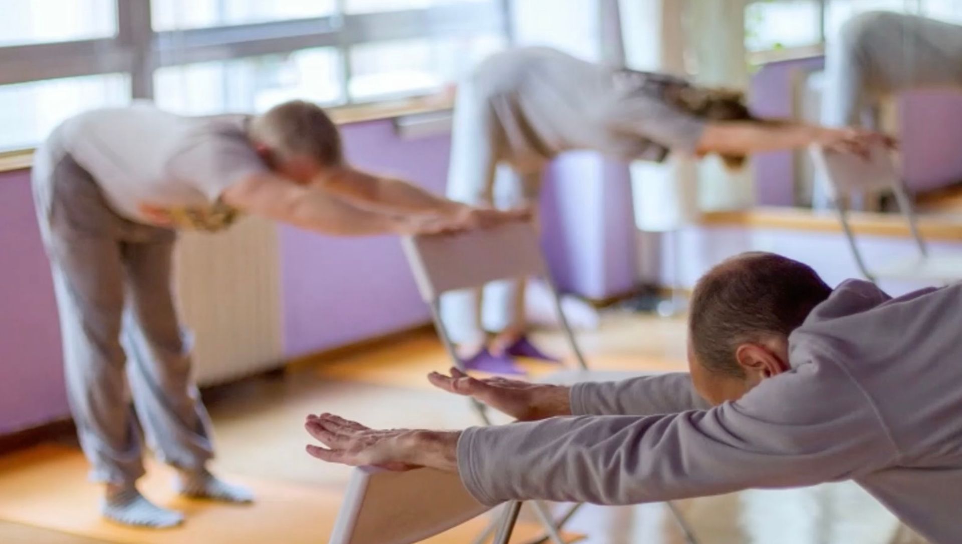people using chairs to do yoga