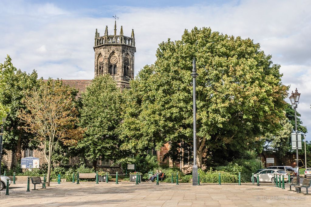 A church tower is surrounded by trees in a park. st mary's atherstone warwickshire