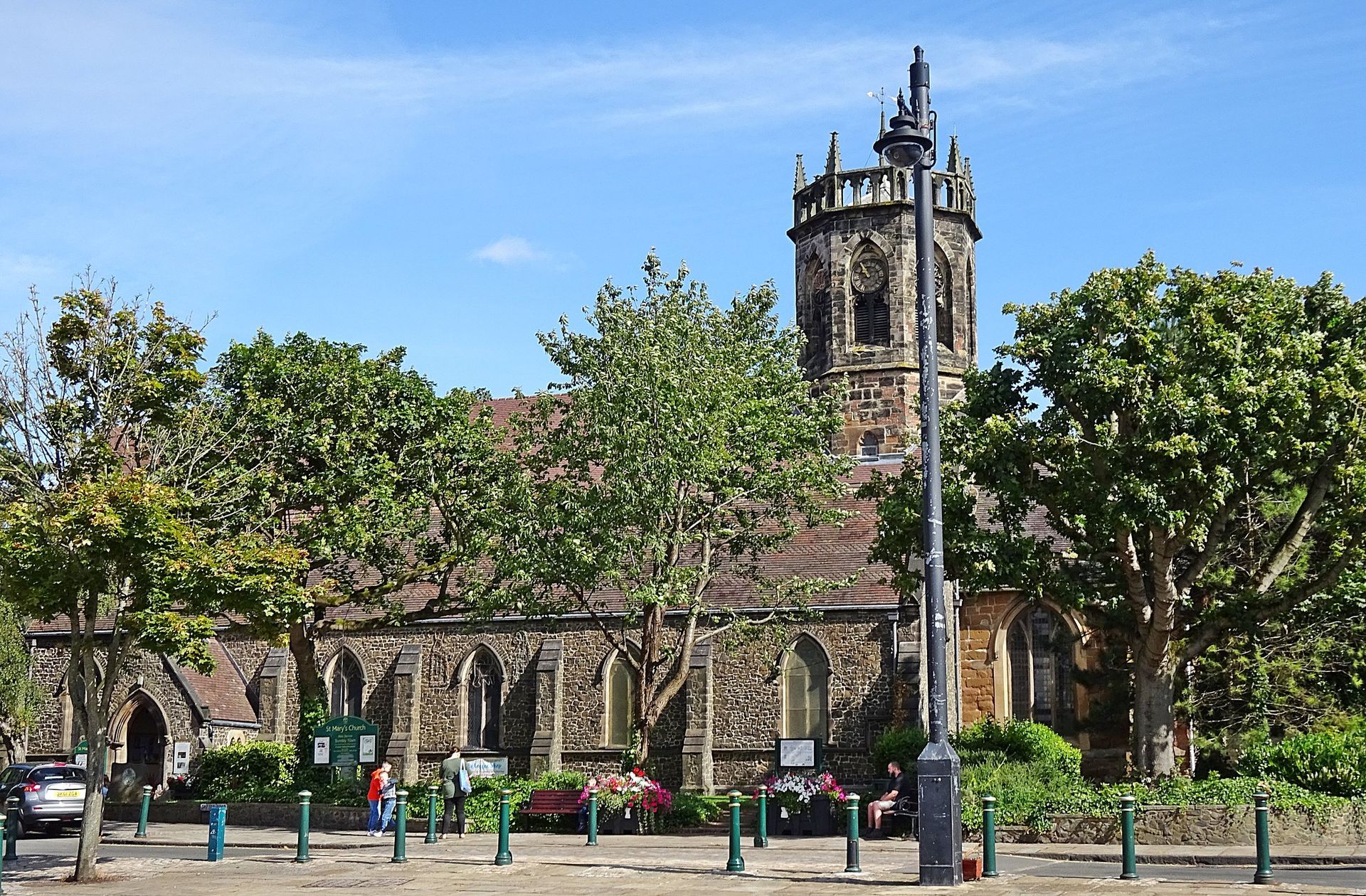 A church is surrounded by trees on a sunny day st mary's atherstone warwickshire