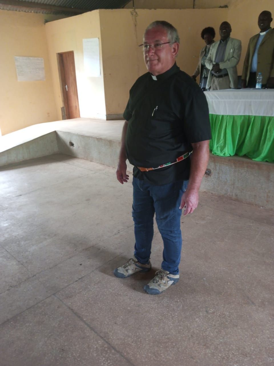 A man in a black shirt is standing in an empty room