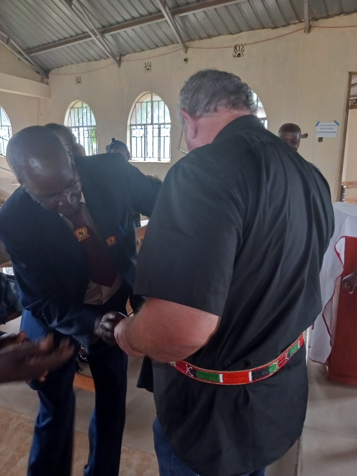 A man in a black shirt is standing next to another man