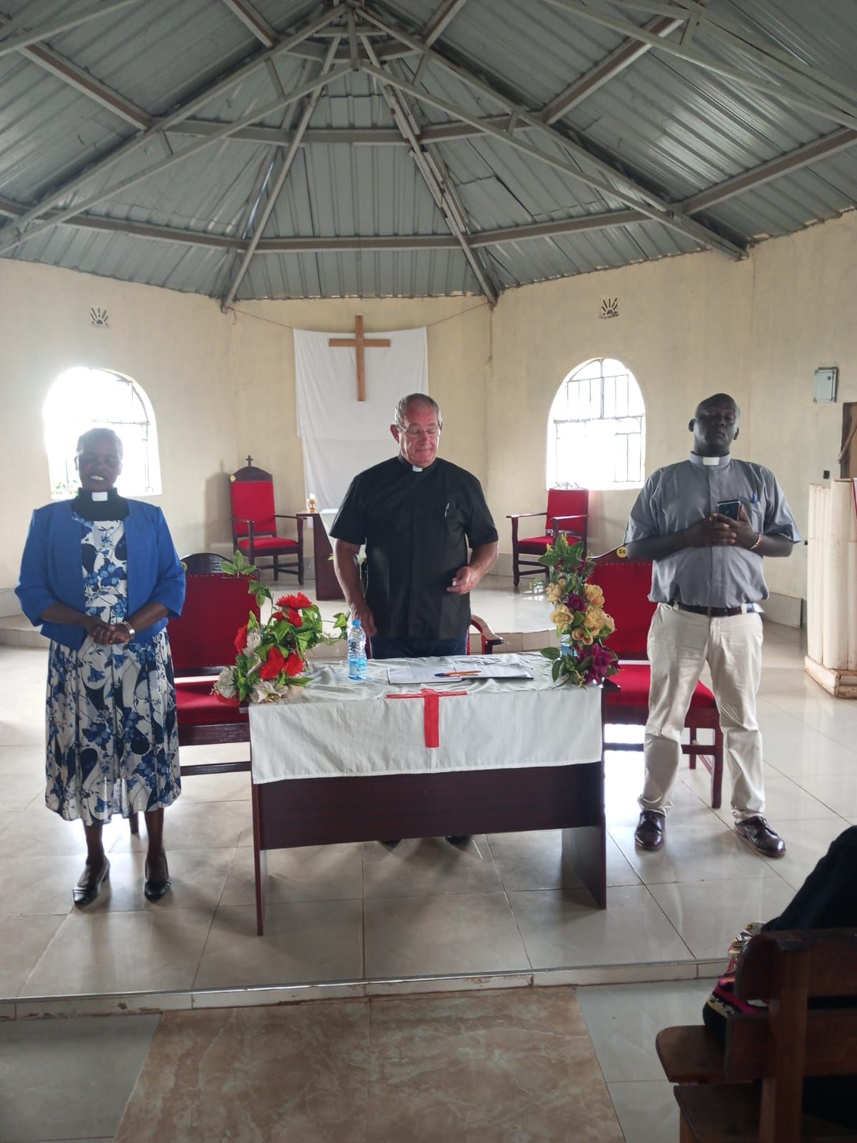 A group of people are standing around a table in a church.