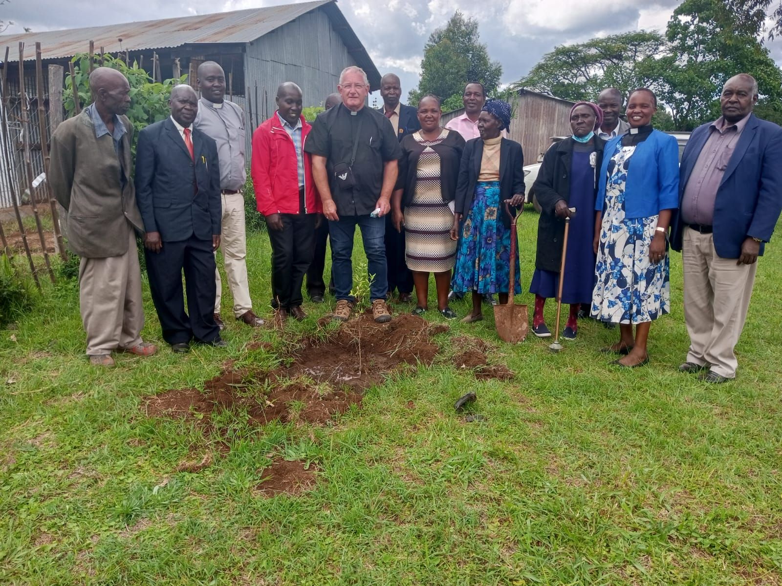A group of people are standing around a hole in the ground.