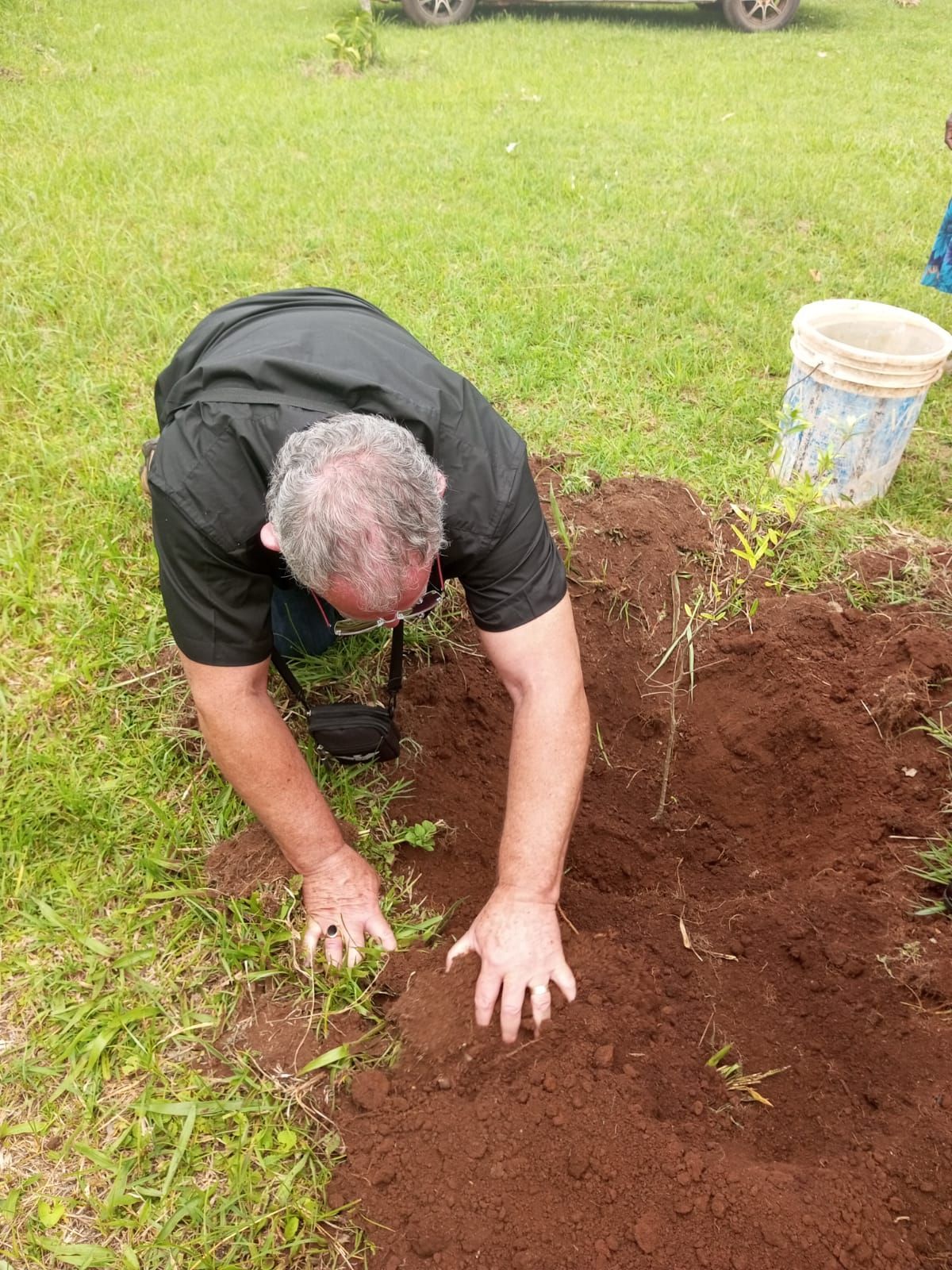 A man is digging in the dirt in a field.