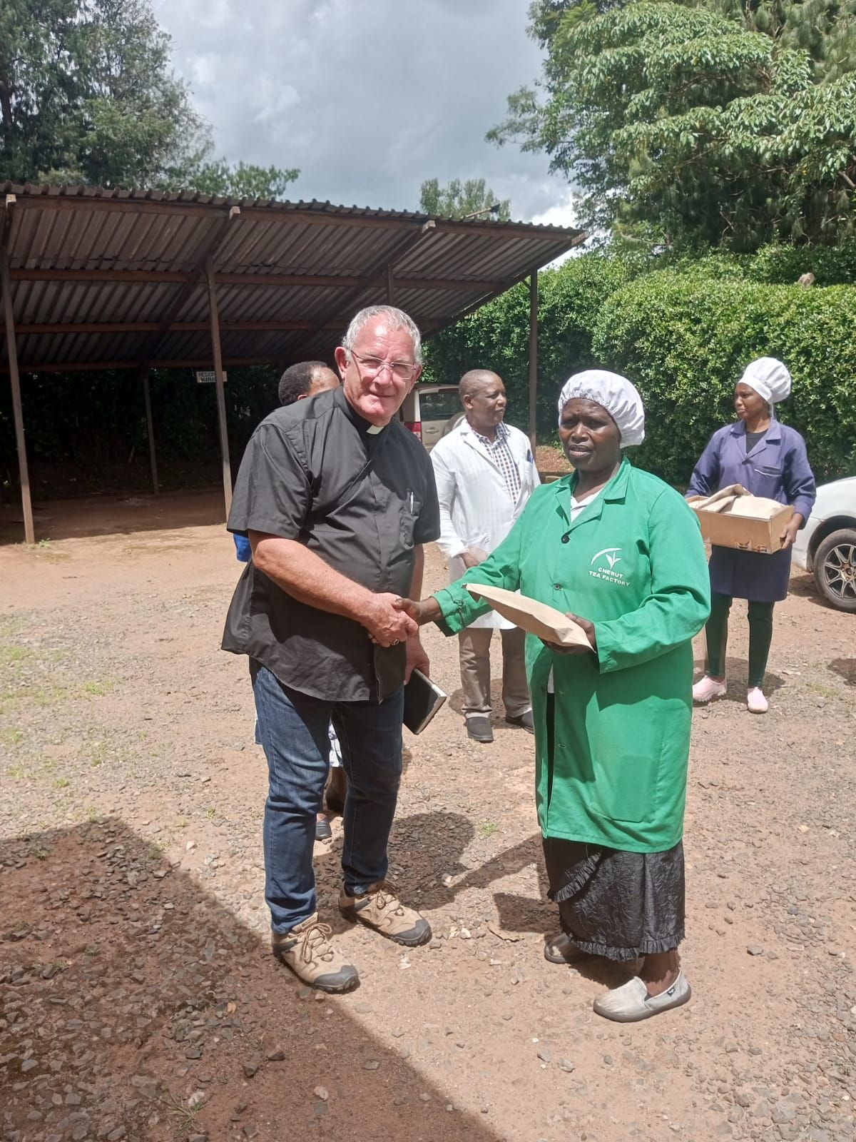 A man is standing next to a woman in a green coat holding a piece of paper.