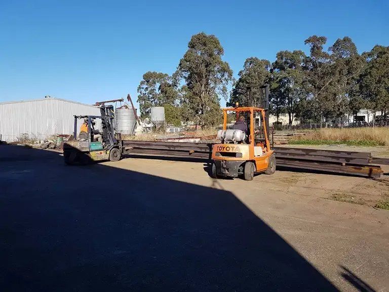 A Forklift Is Carrying a Large Piece of Metal in A Yard — Mayric Engineering in  Old Bar, NSW