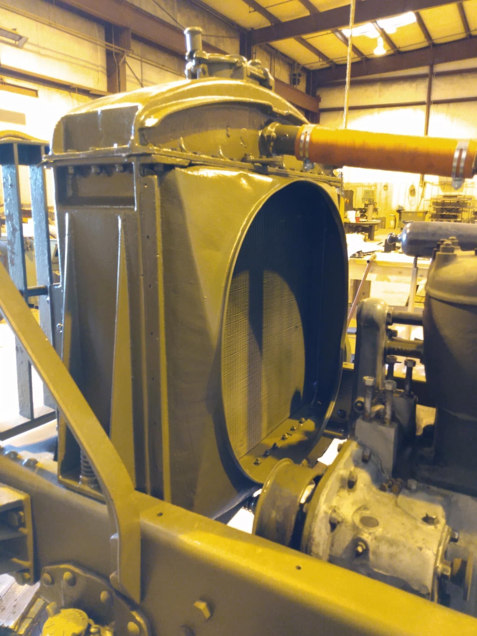 Yellow industrial machine with a large circular opening inside a workshop or factory.