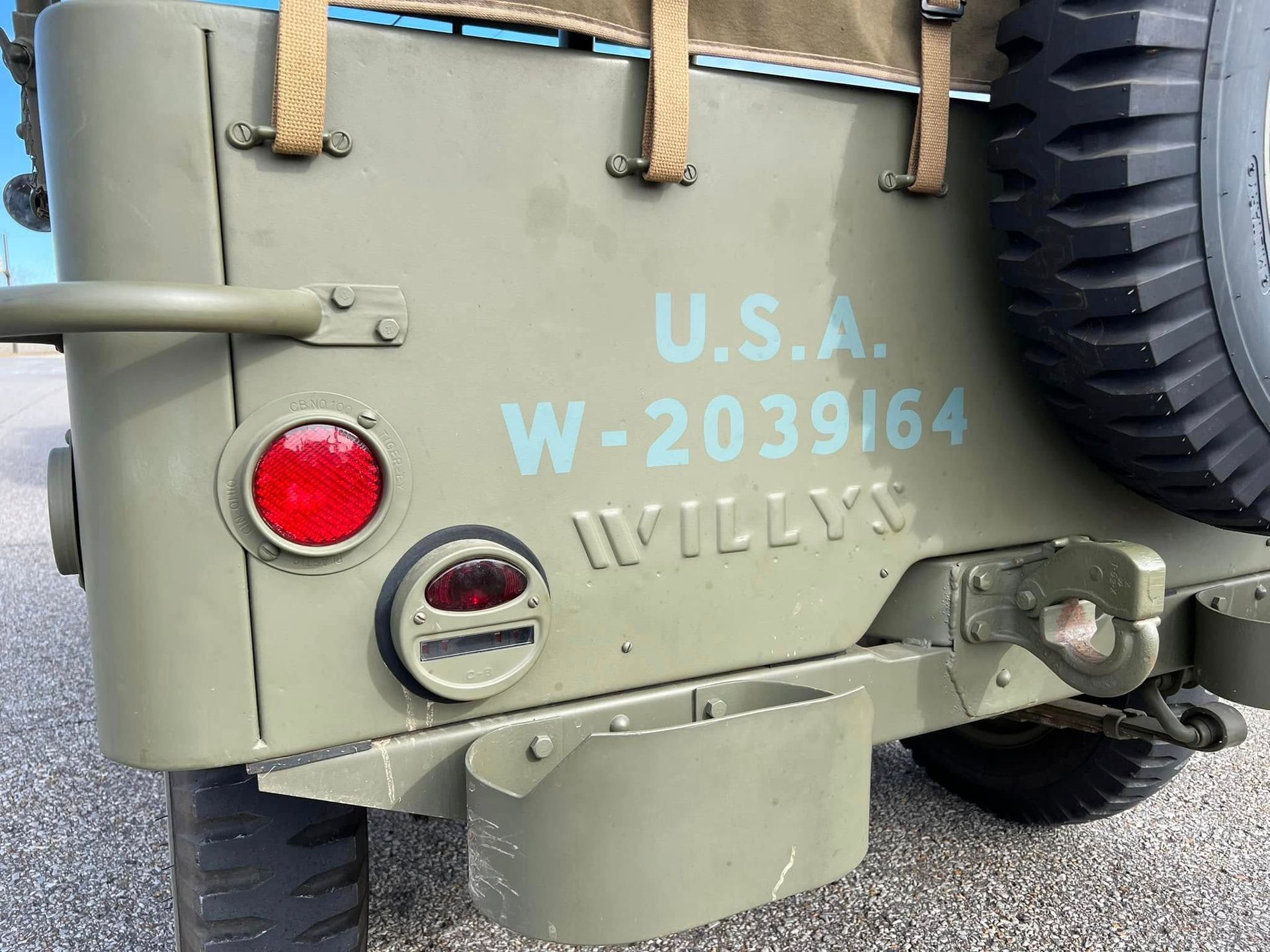 Olive drab WWII military jeep rear with U.S.A. W-2039164 stencil and spare tire[0m