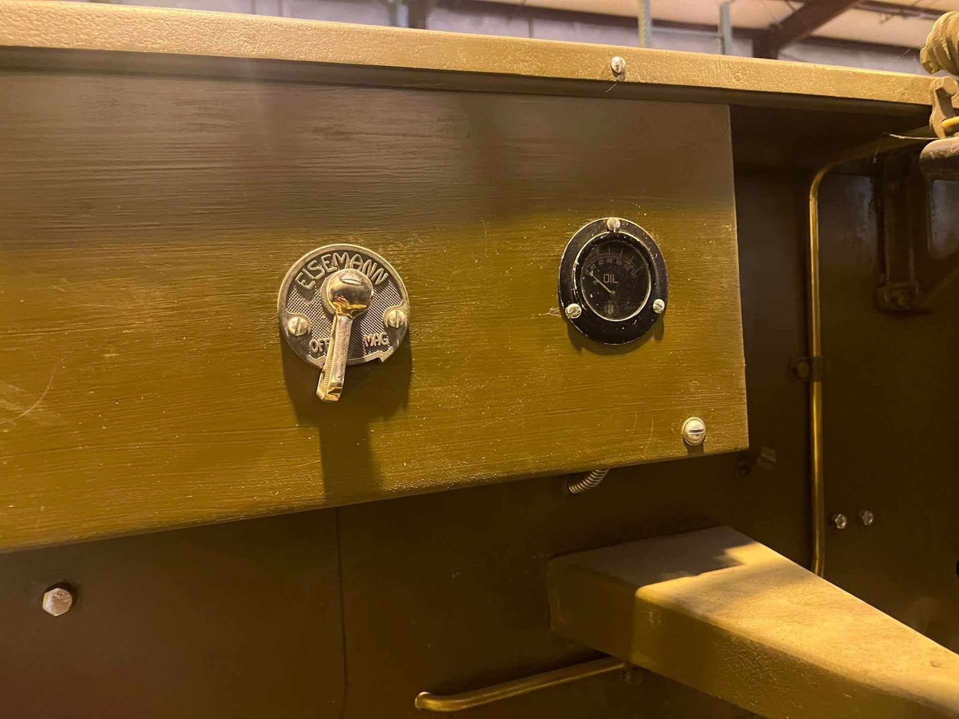 Close-up of two vintage dials mounted on a wooden machine panel with a lever below