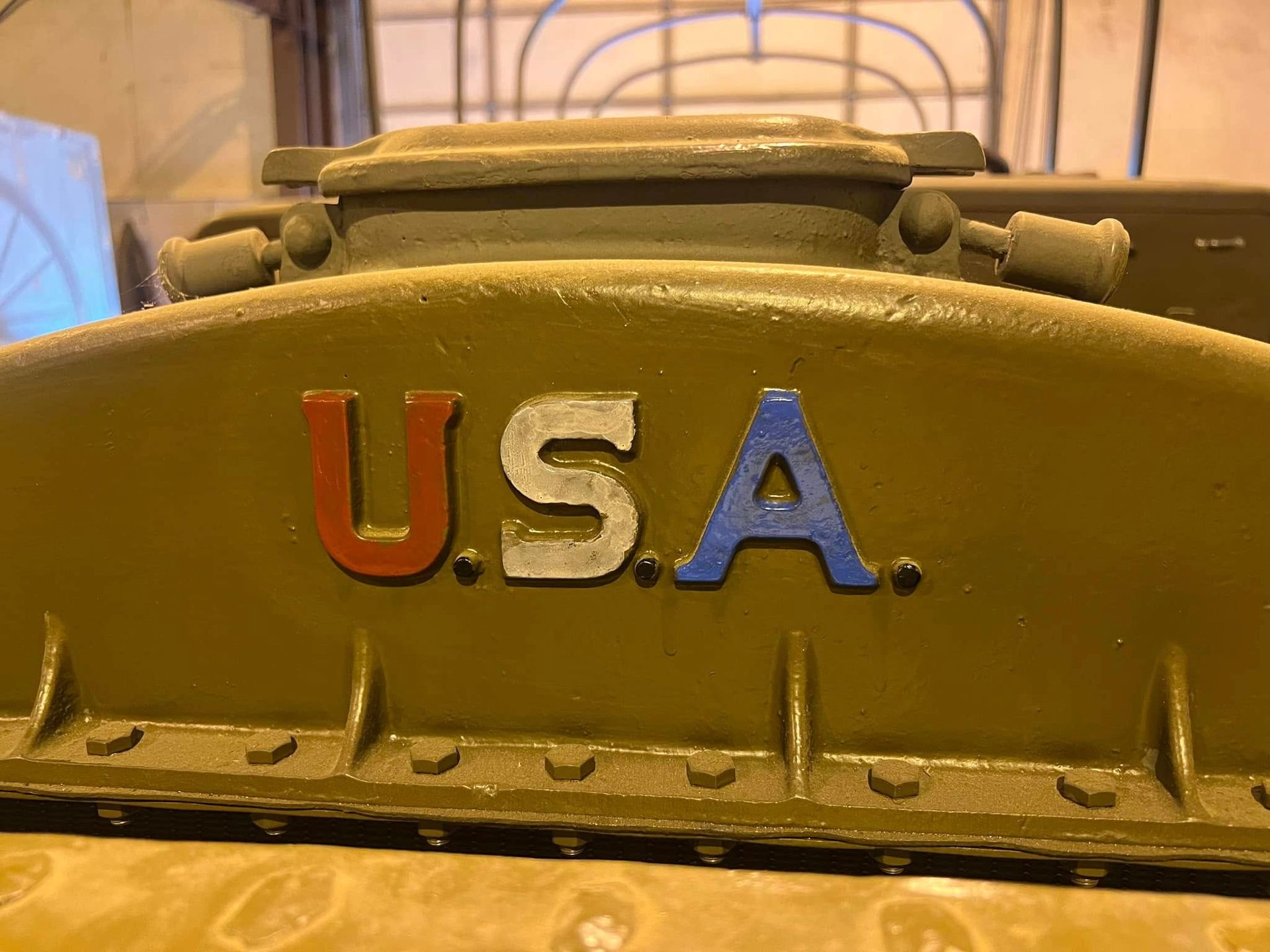 Close-up of a yellow machine panel with colorful raised “U.S.A.” lettering