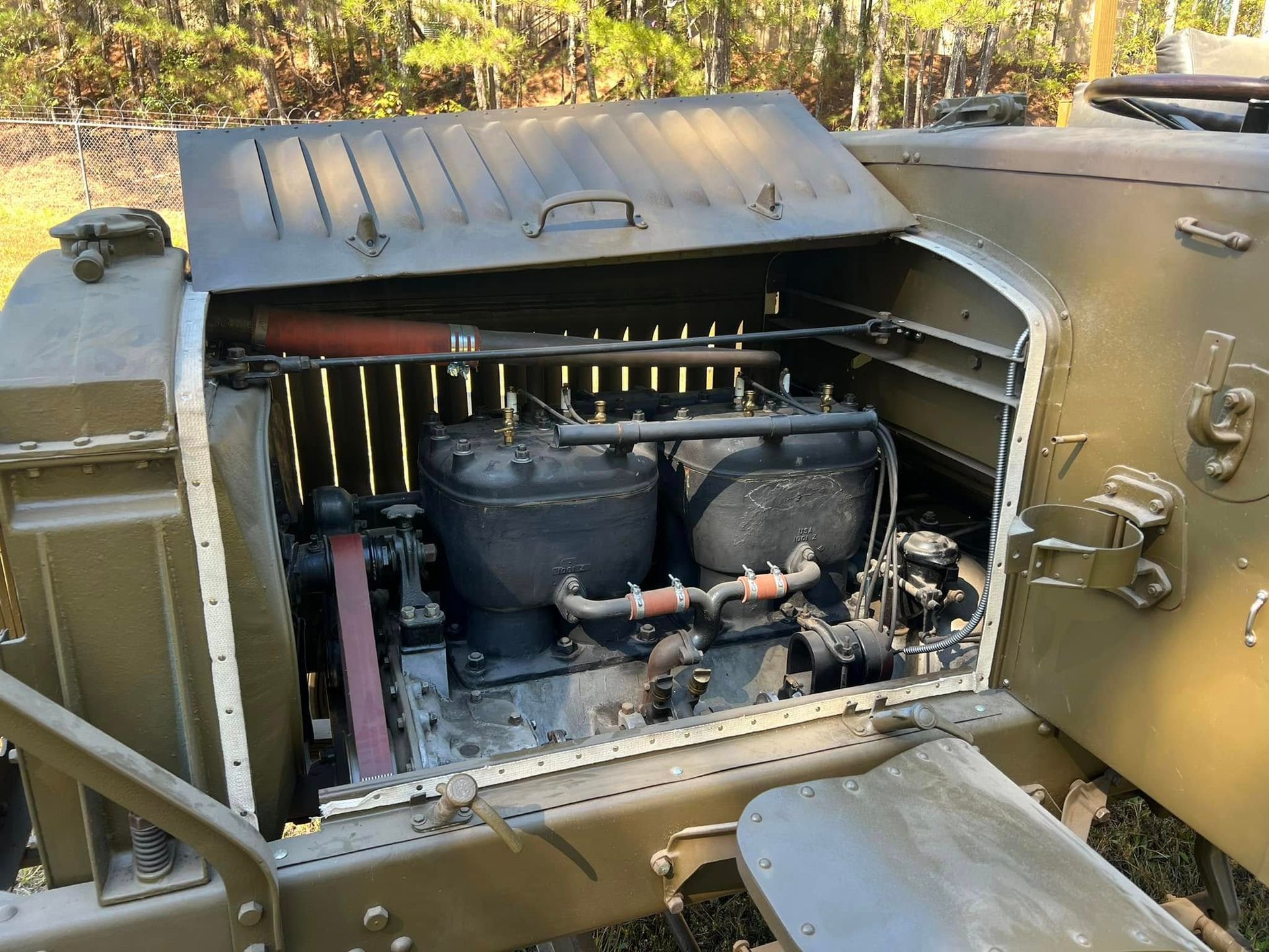 Open tank compartment with two black batteries and exposed machinery inside a military vehicle.
