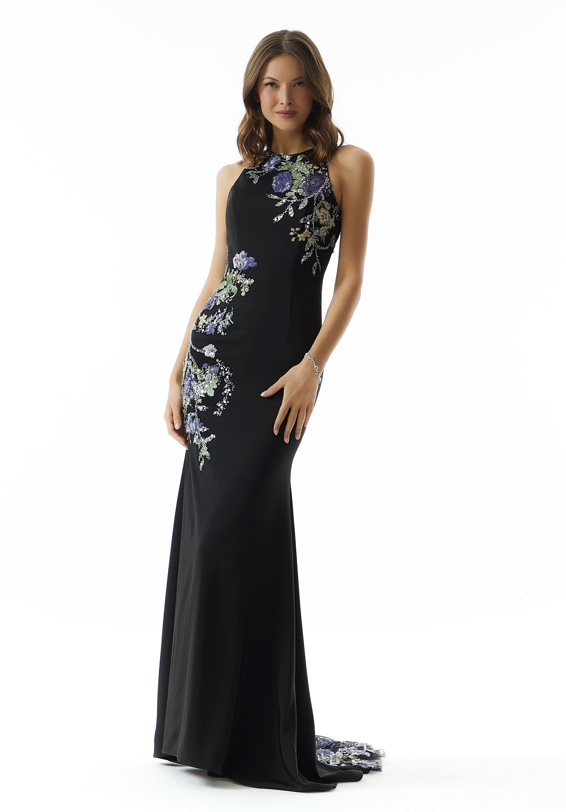 A woman is wearing a black dress with purple flowers on it.