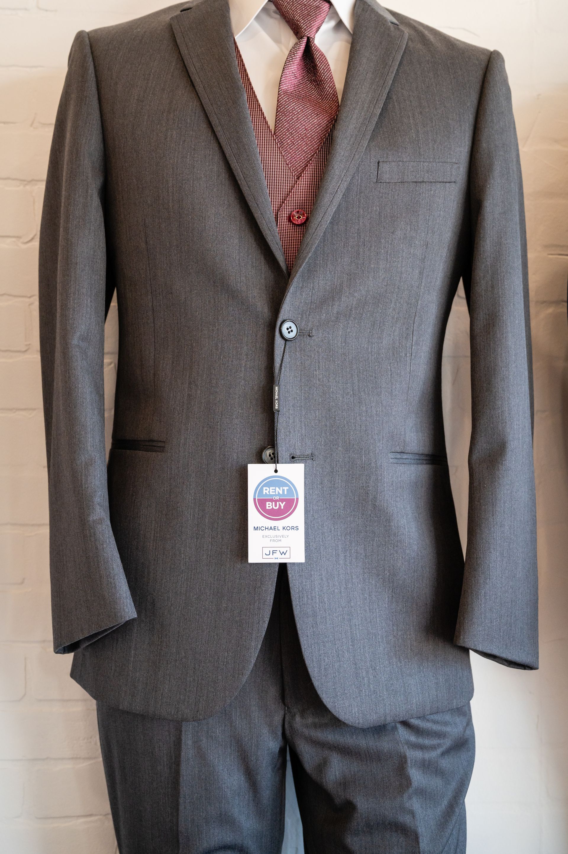 A man is wearing a grey suit and tie