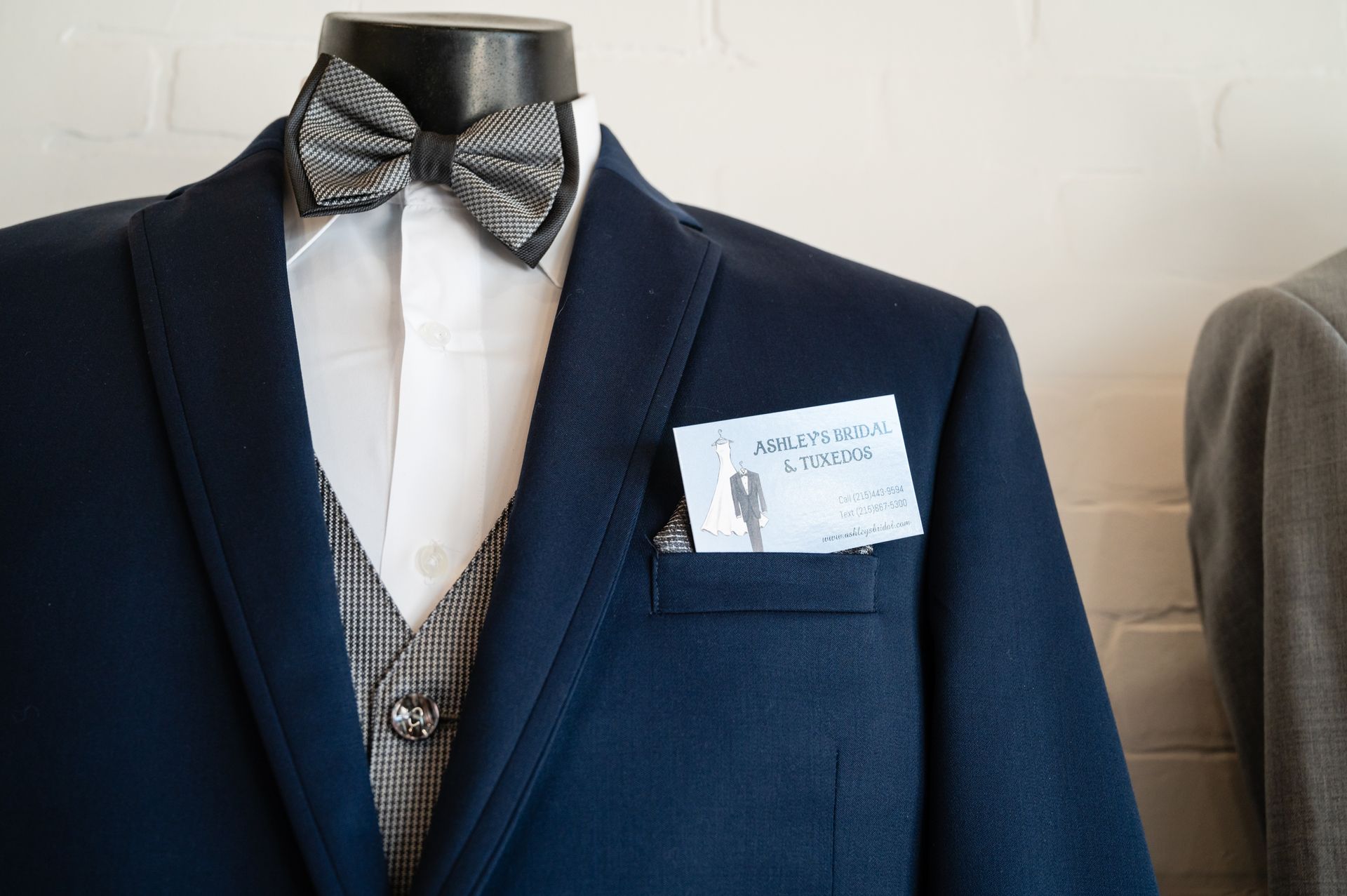 A blue suit with a bow tie is on a mannequin