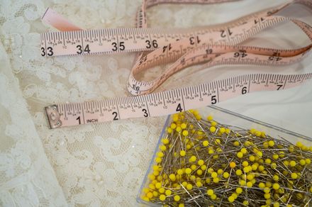 A measuring tape is next to a box of yellow pins