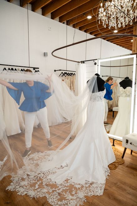 A woman is trying on a wedding dress in a bridal shop.