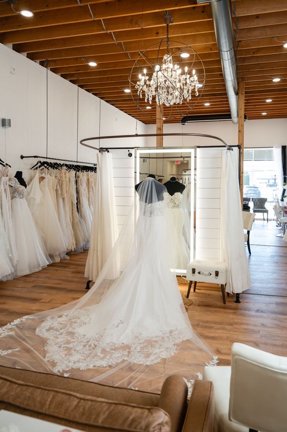 A wedding dress is hanging in a bridal shop.