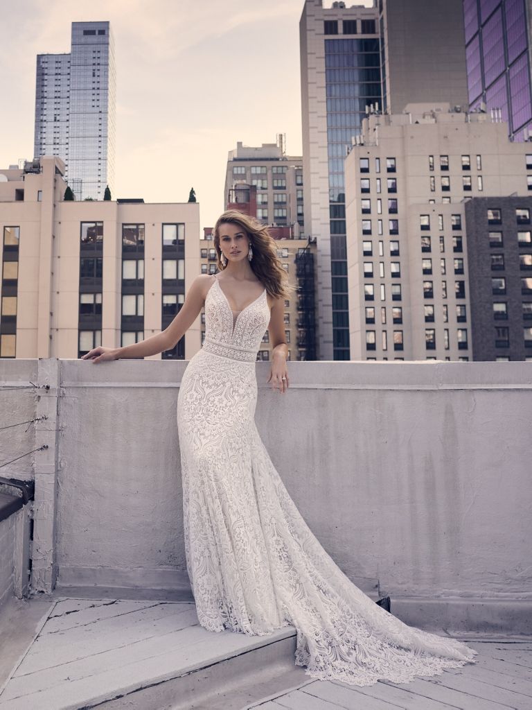 A woman in a wedding dress is standing on top of a building