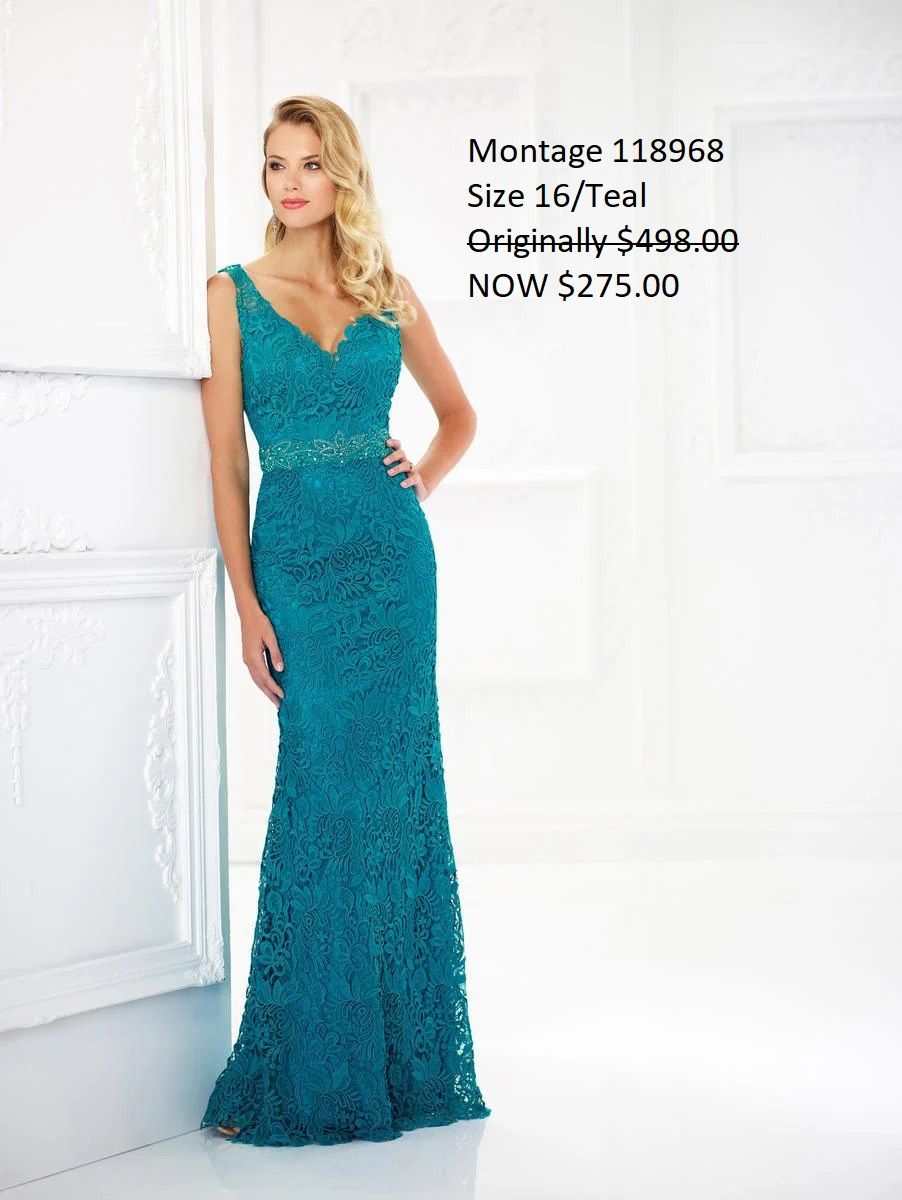 A woman in a blue lace dress is standing in front of a white wall.